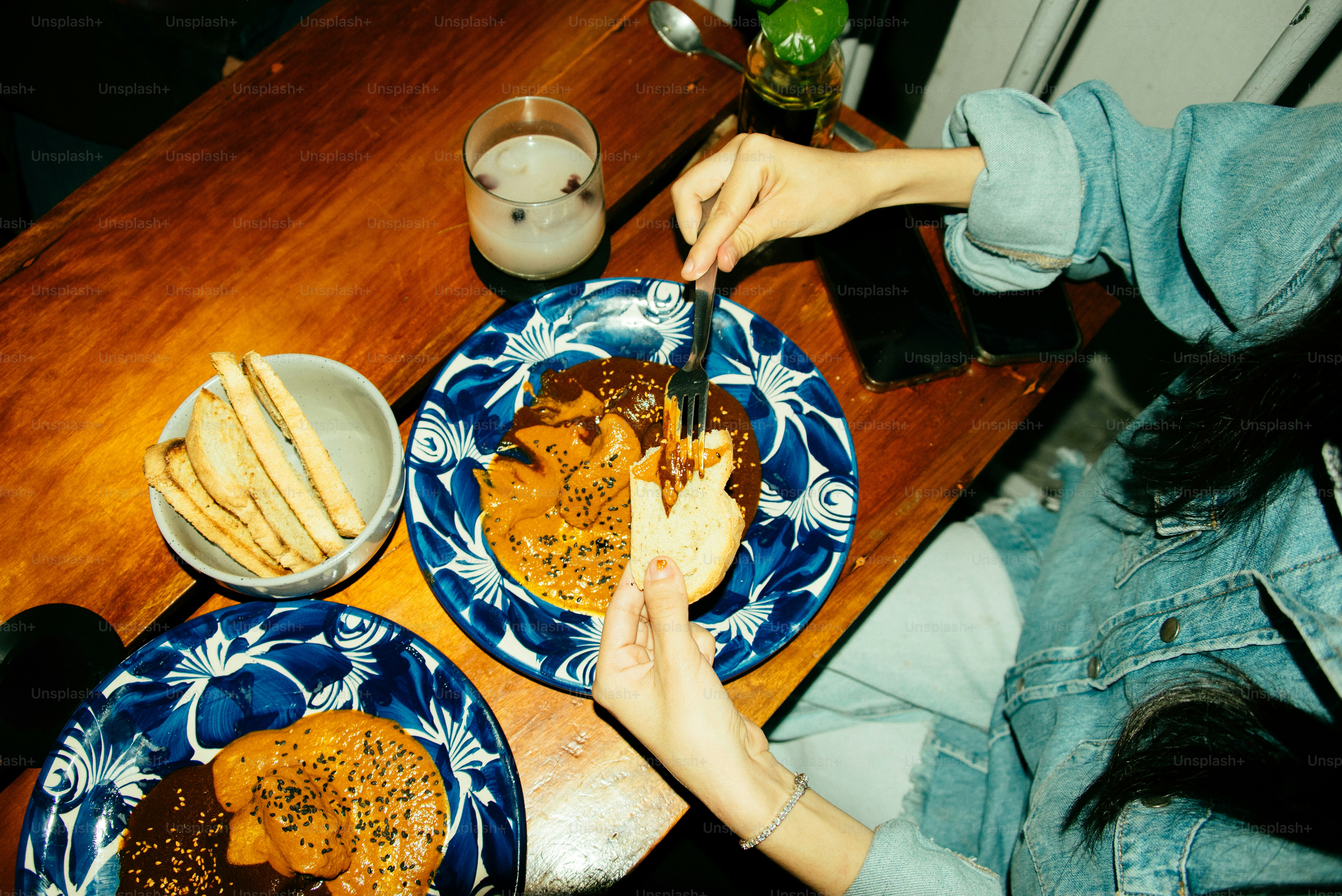 A woman sitting at a table with two plates of food