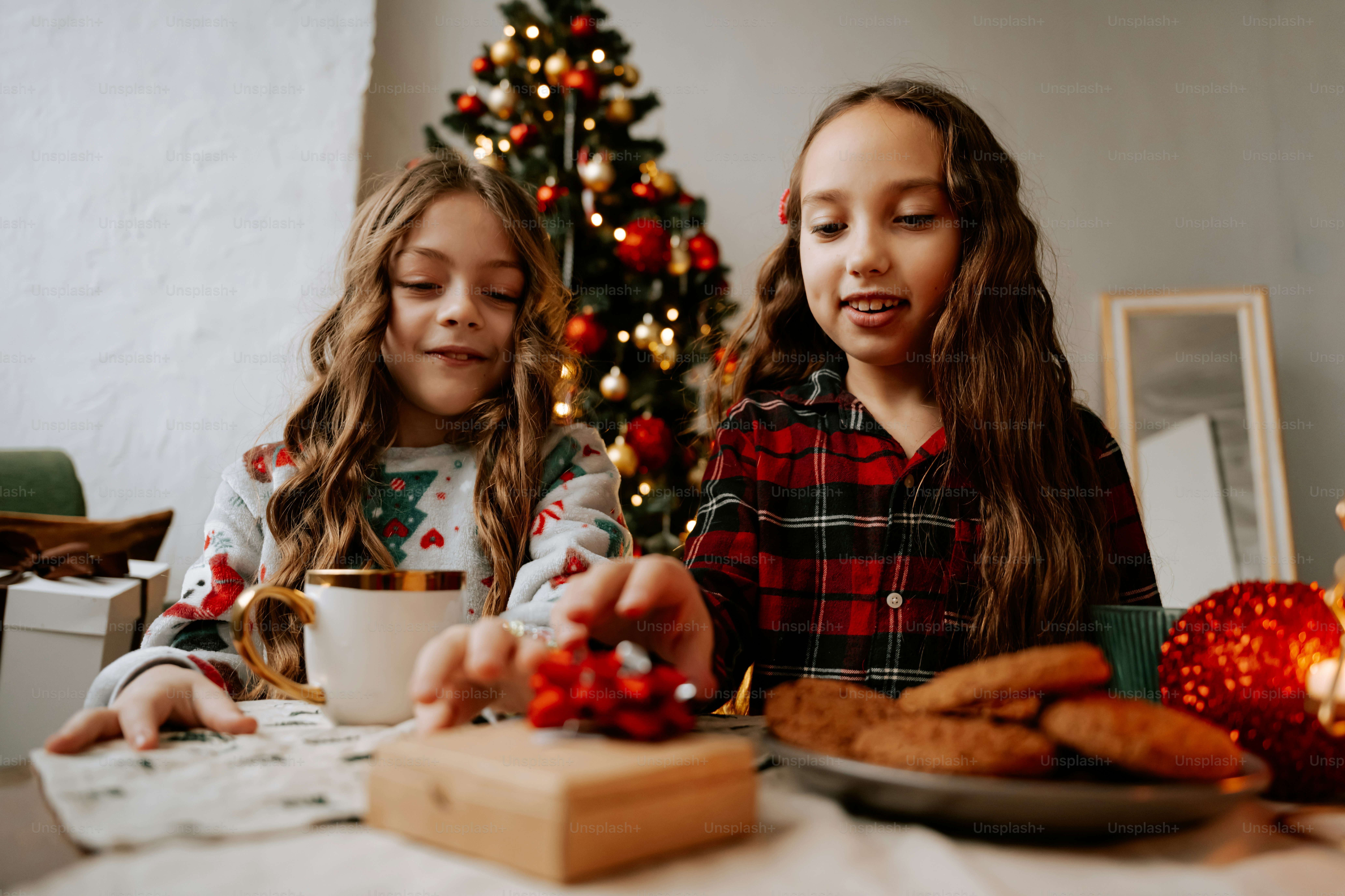 Two little girls sitting at a table with food