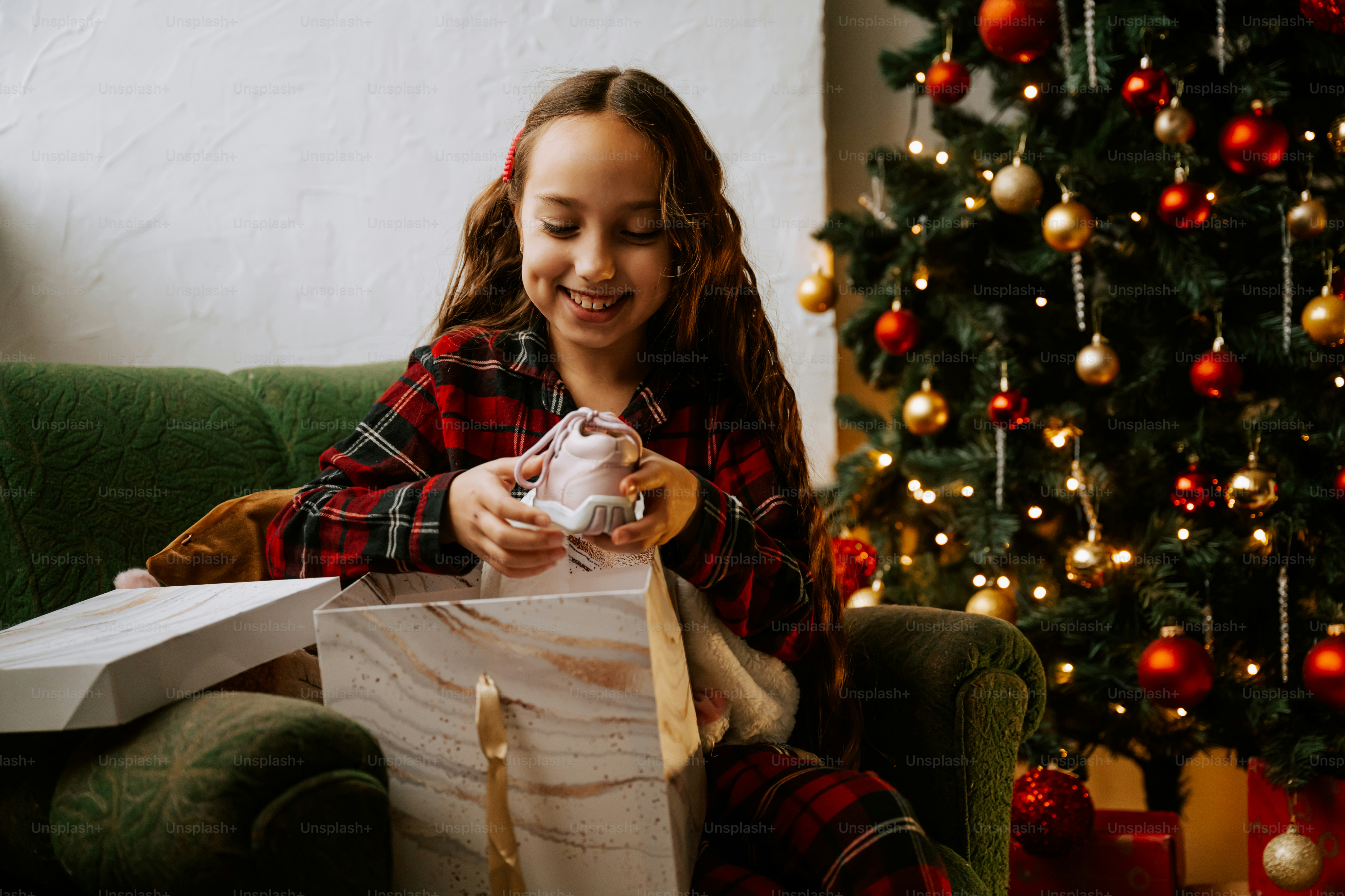A young girl sitting on a couch holding a wrapped present