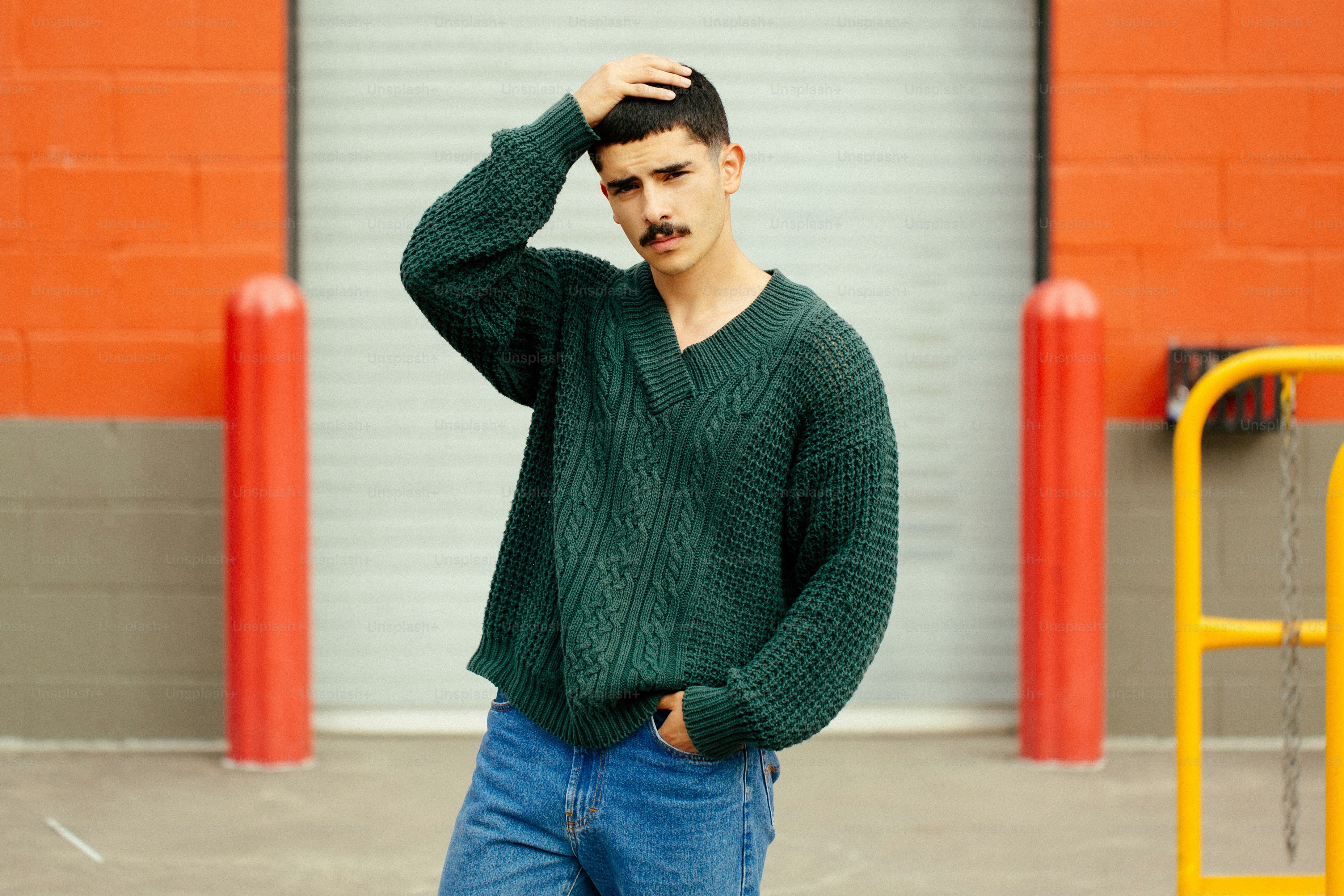 Un uomo, in piedi di fronte a un edificio, con la mano sulla testa