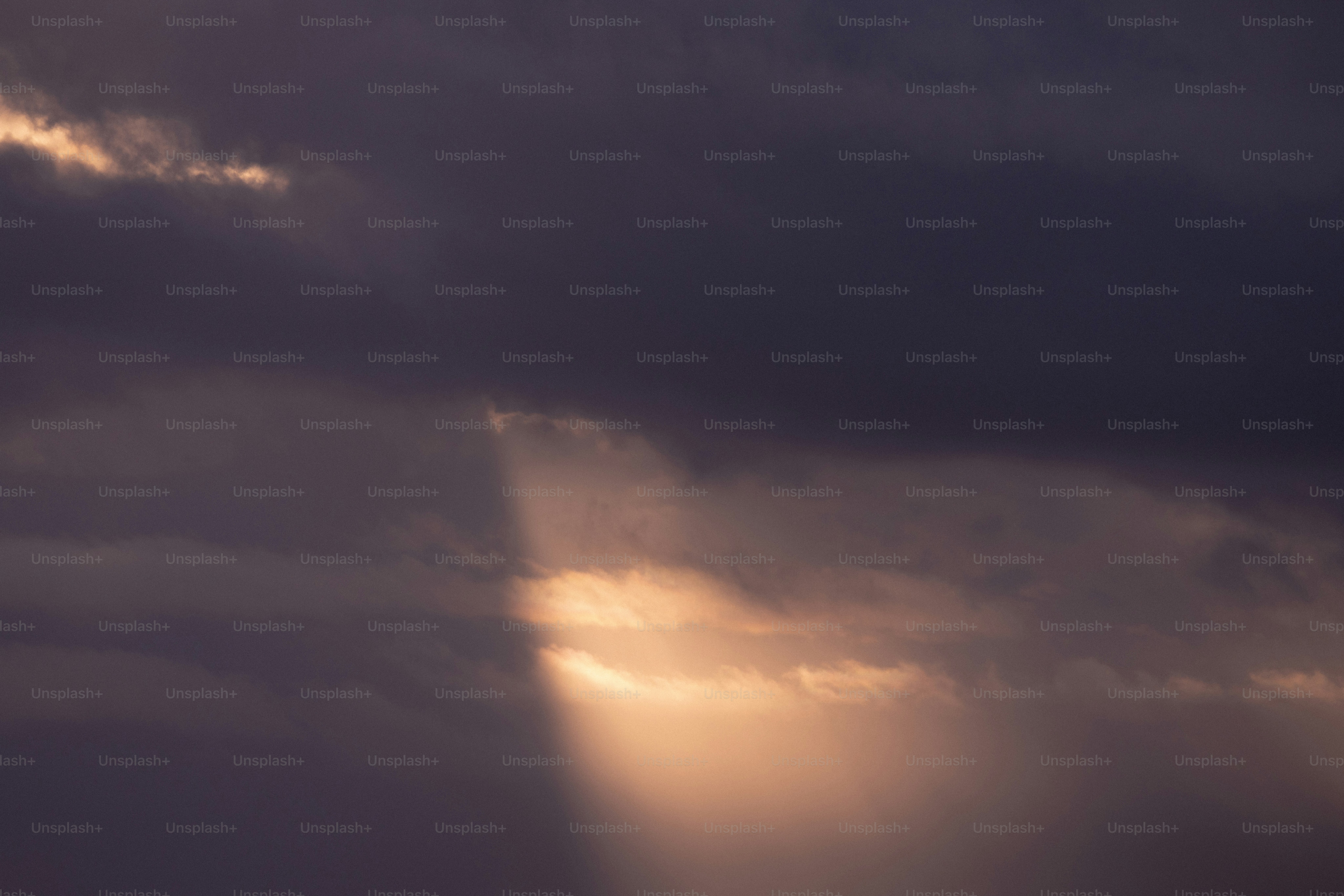 The sun is shining through the clouds in the sky
