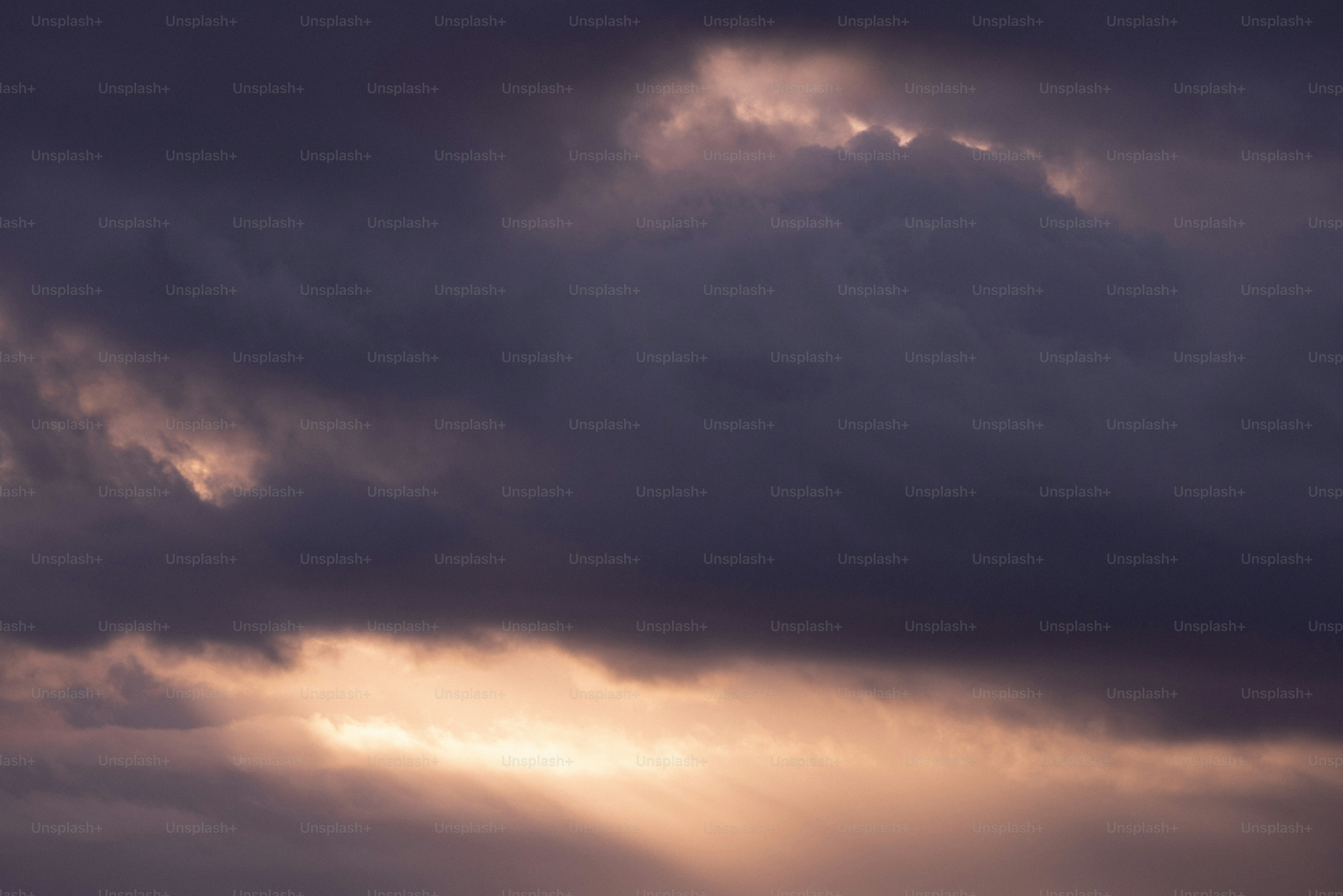 The sun is shining through the clouds over the ocean