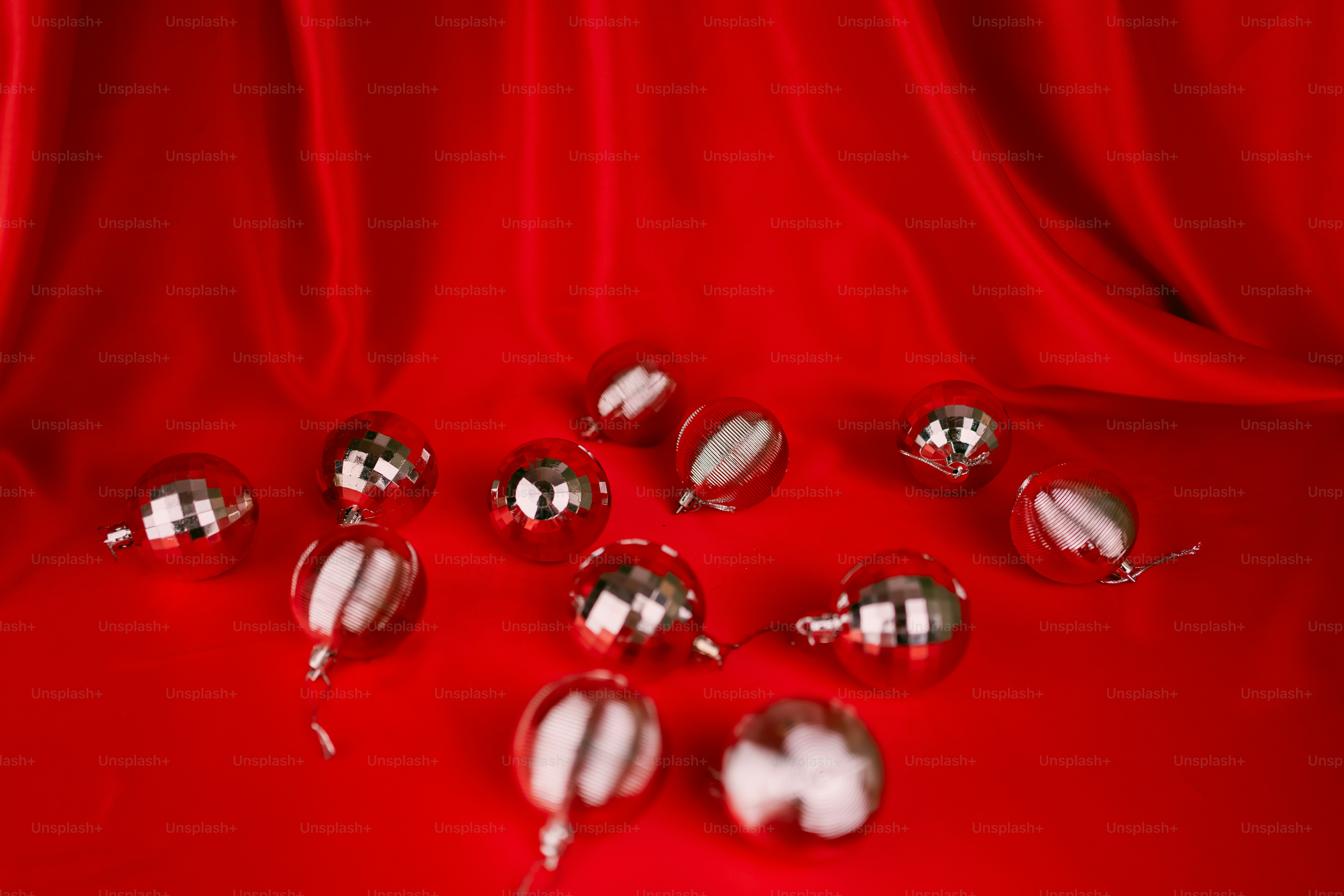 Un montón de bolas plateadas brillantes sobre un fondo rojo