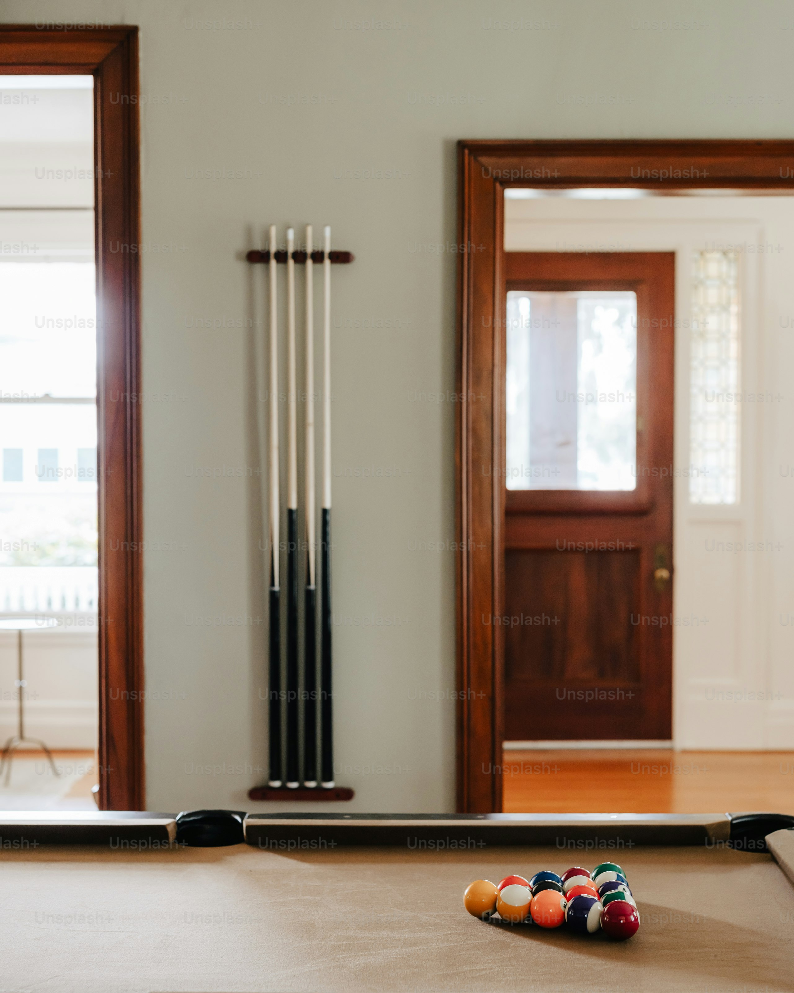 A pool table in a room with two doors