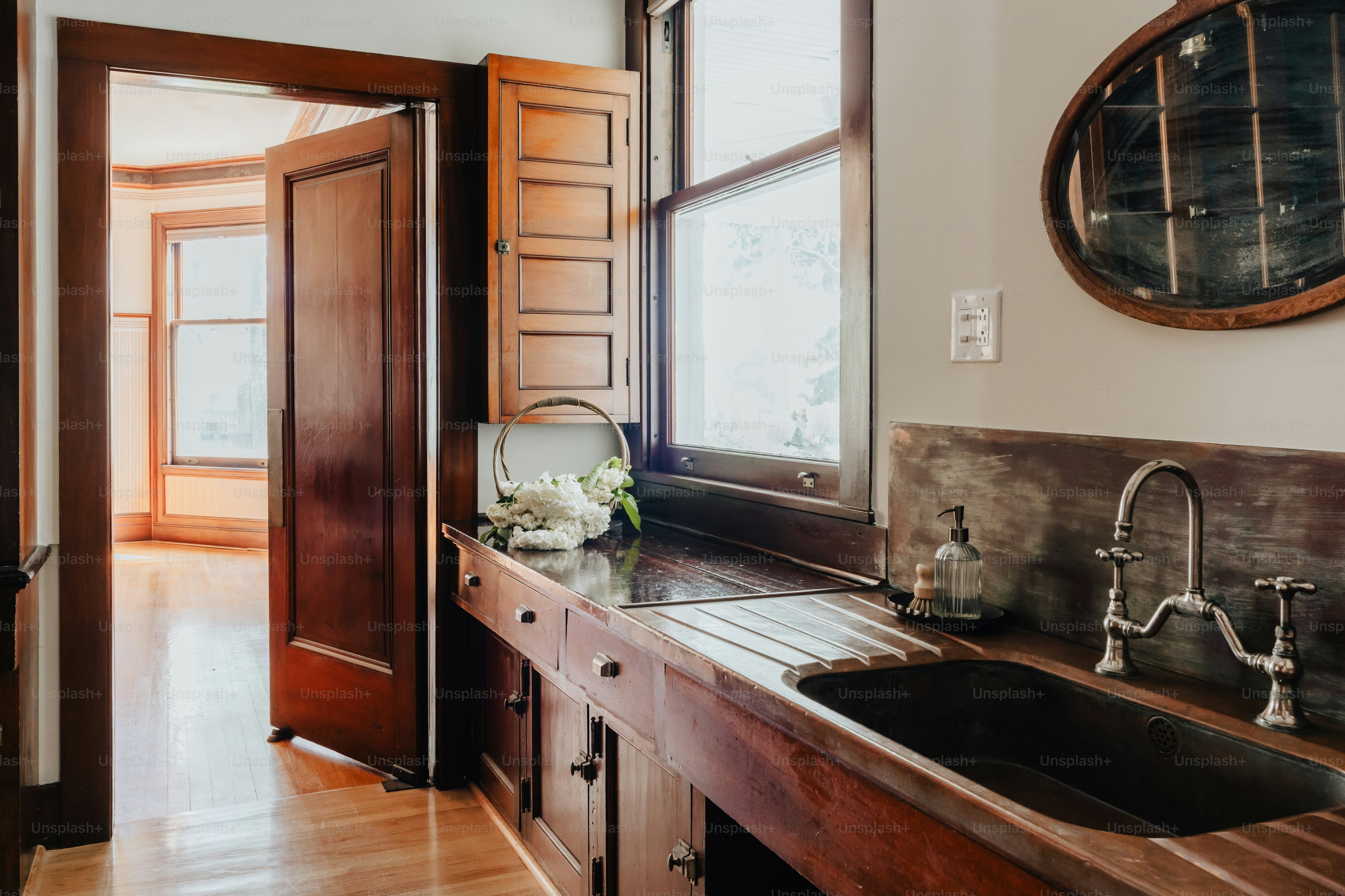 A kitchen with a double sink and wooden cabinets
