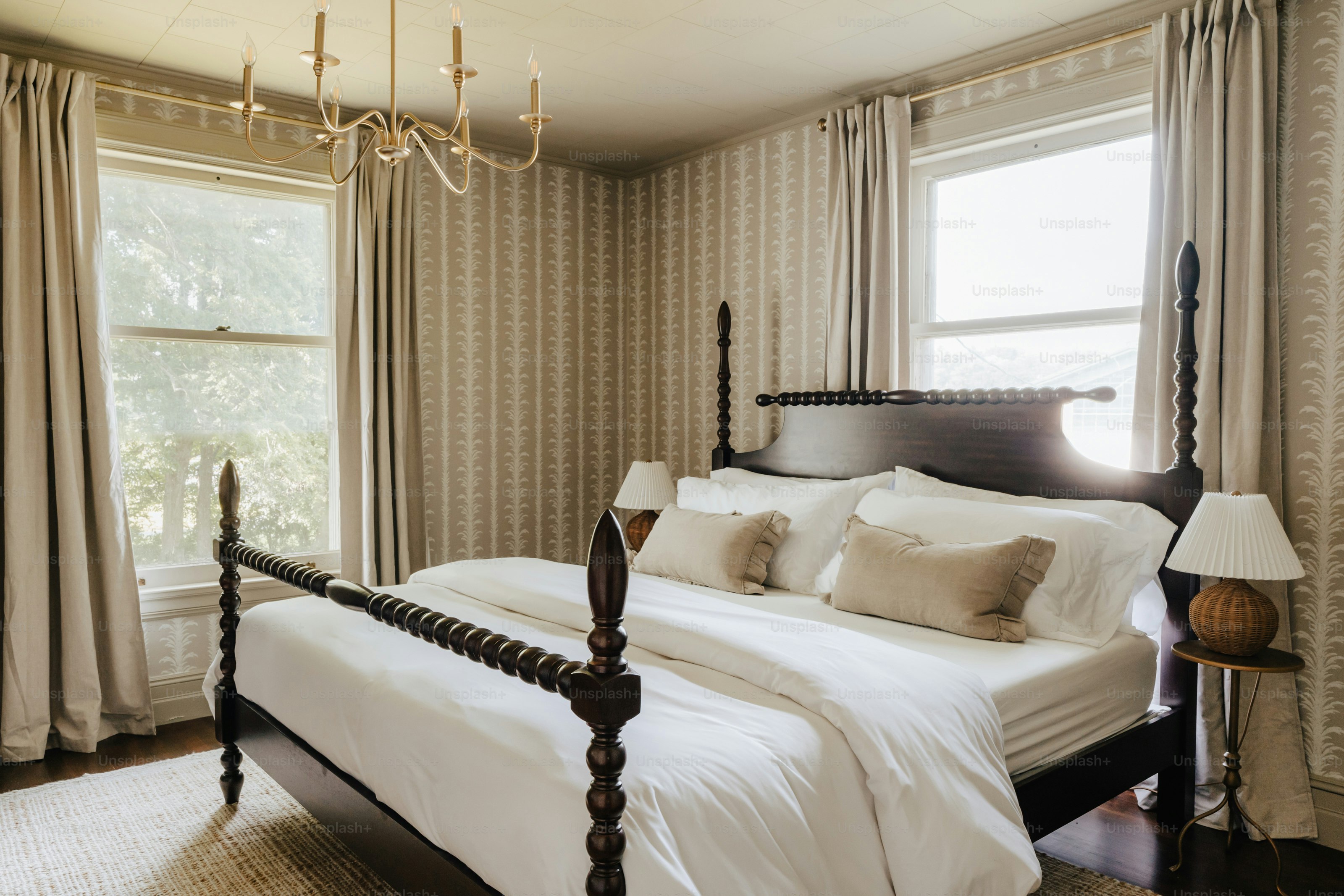 A bedroom with a large bed and a chandelier