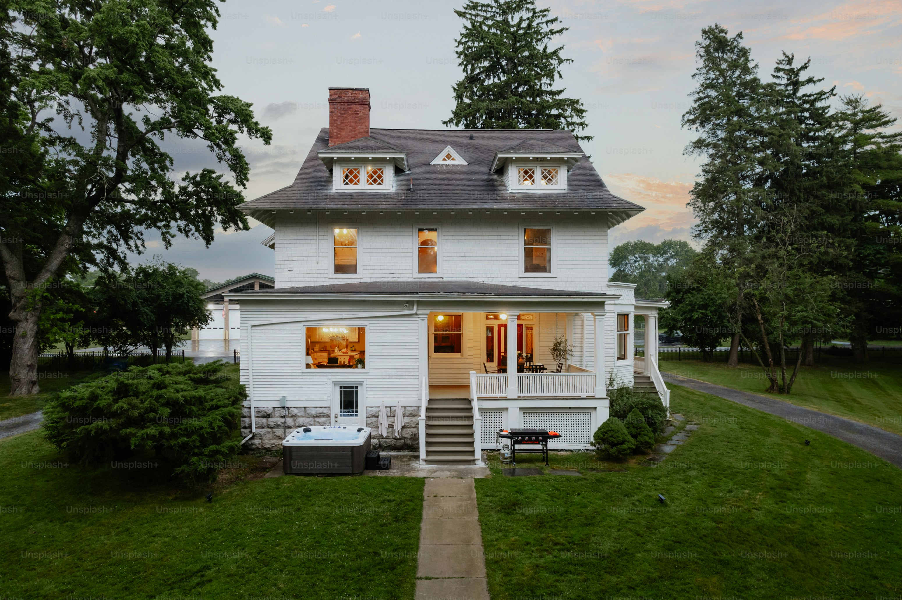 A large white house sitting on top of a lush green field