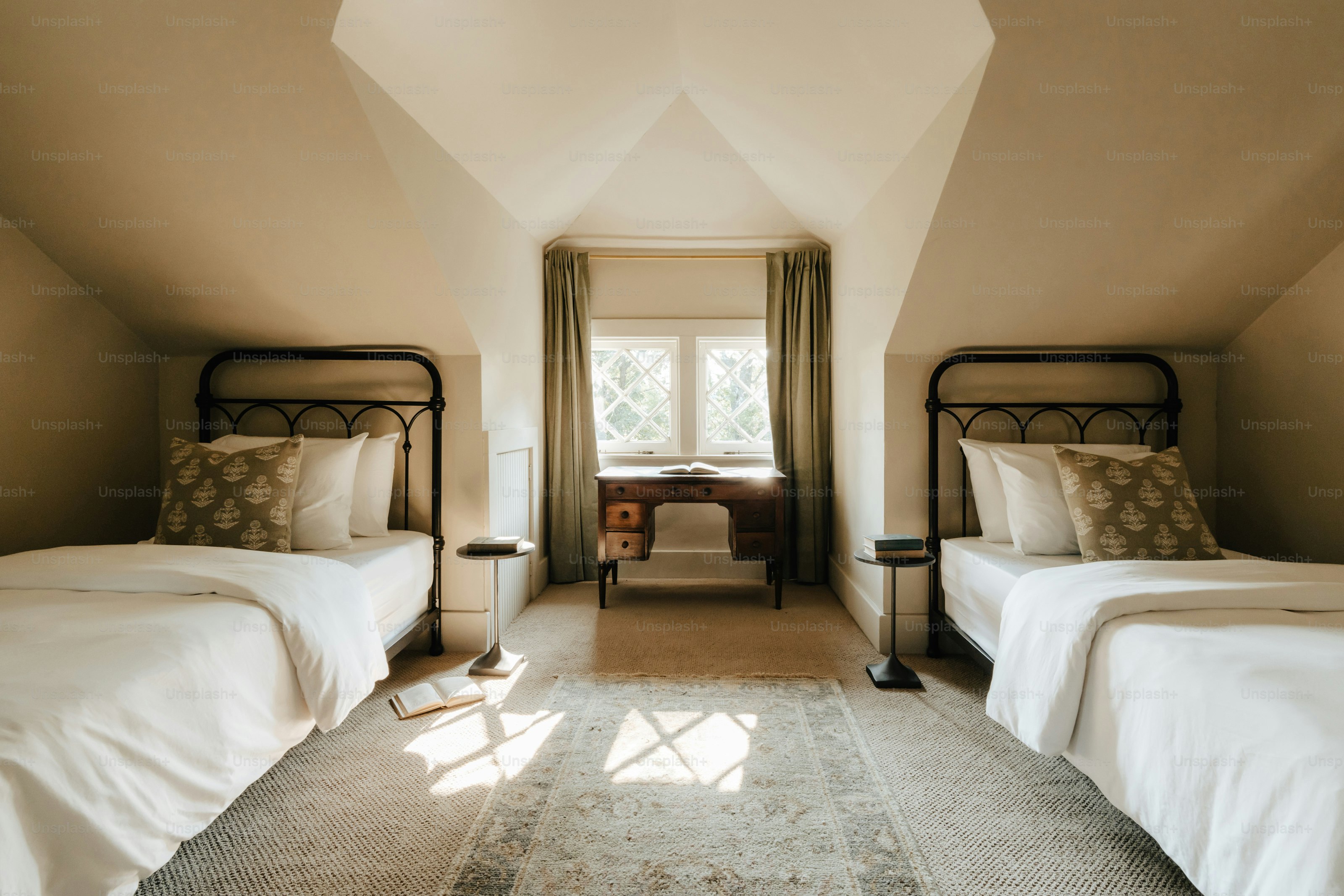 A room with two beds and a rug on the floor