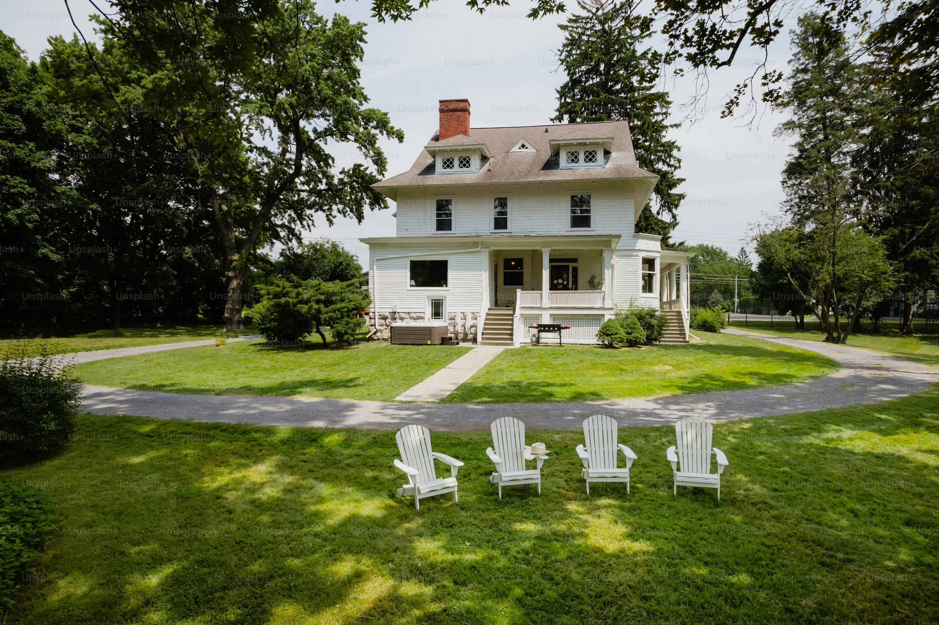 A white house with lawn chairs in front of it
