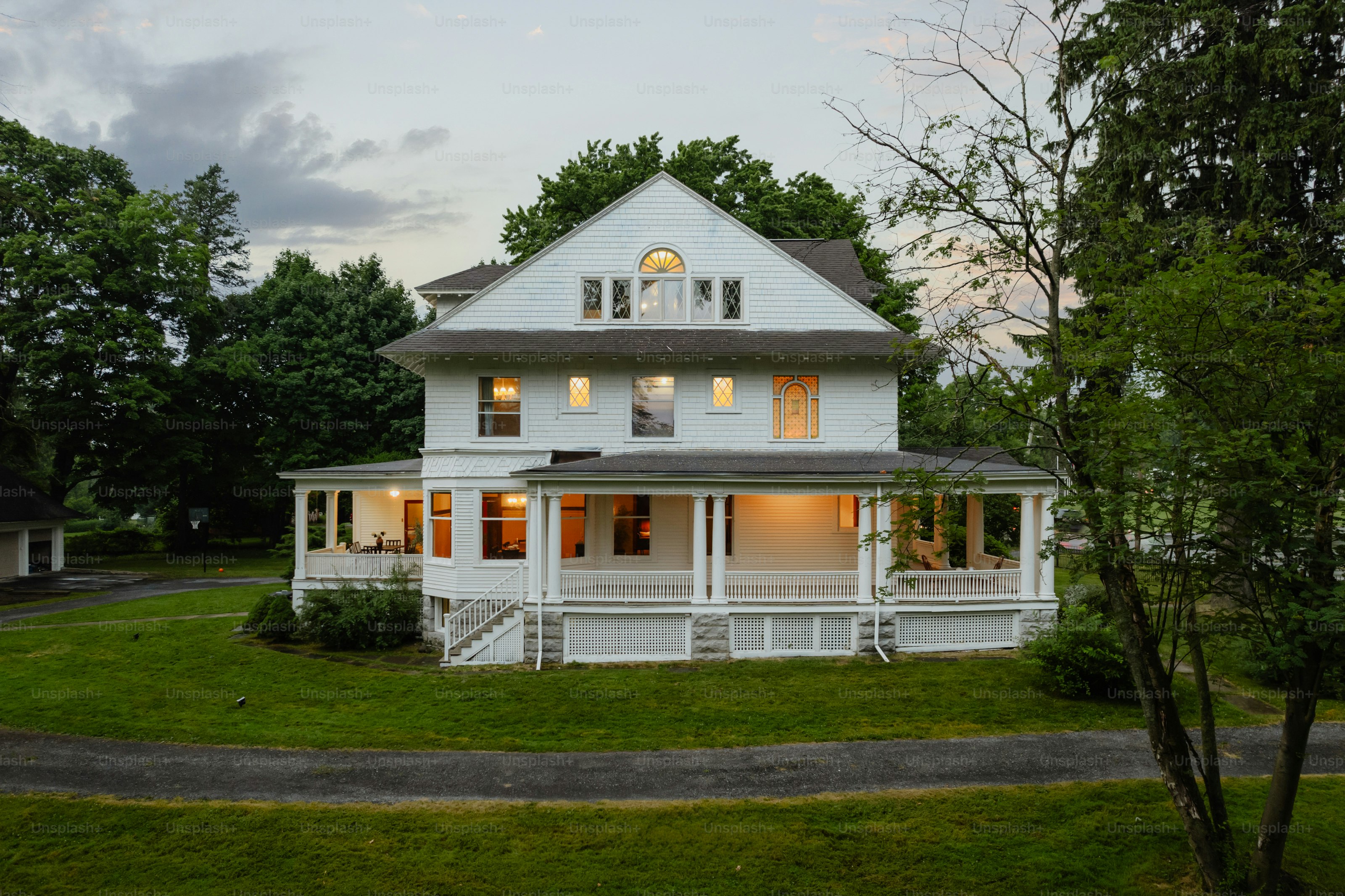 A large white house sitting on top of a lush green field
