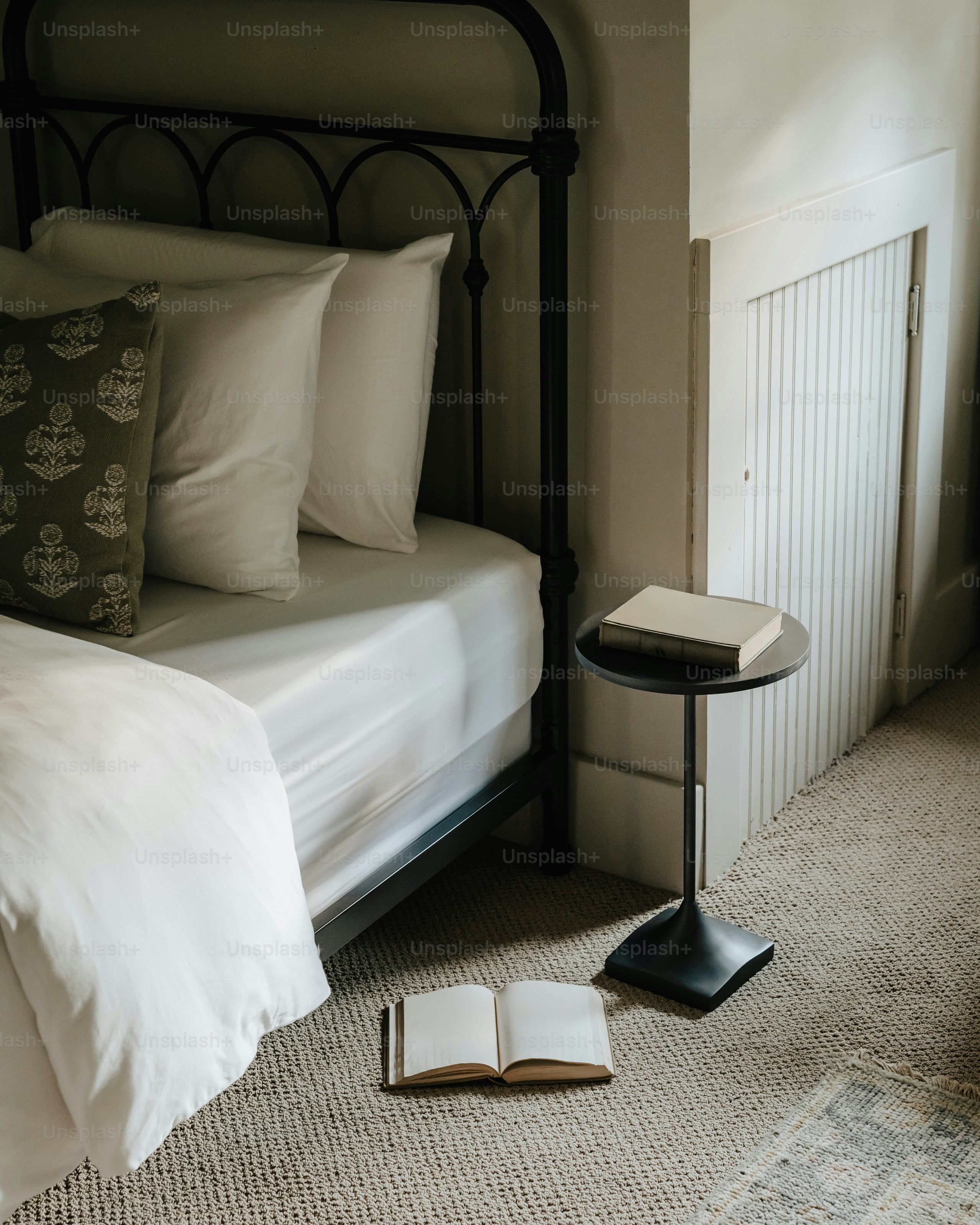 Um quarto com uma cama e um livro no chão