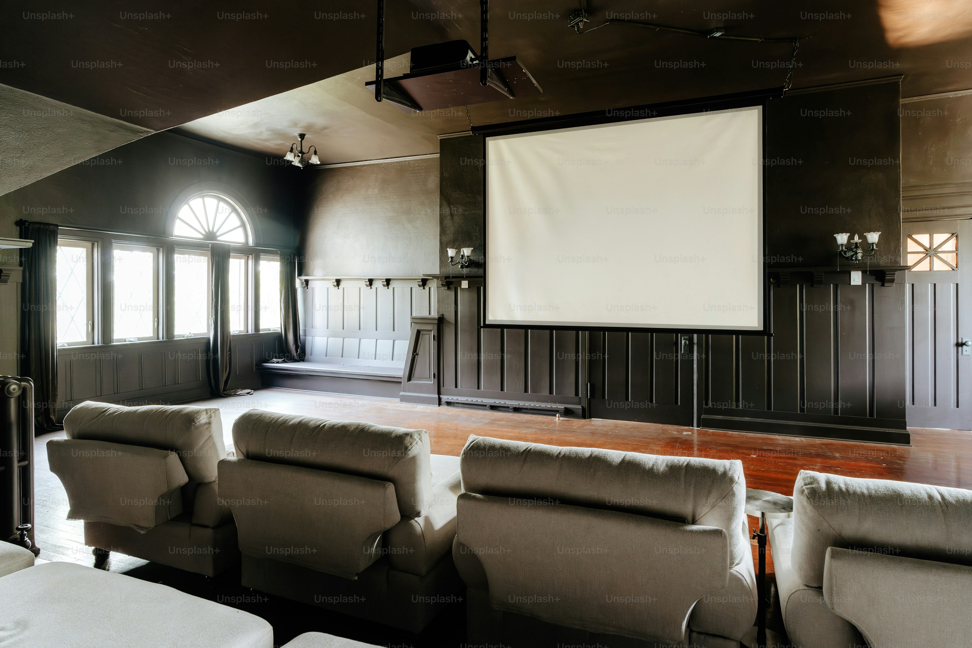 A room with a lot of chairs and a projector screen