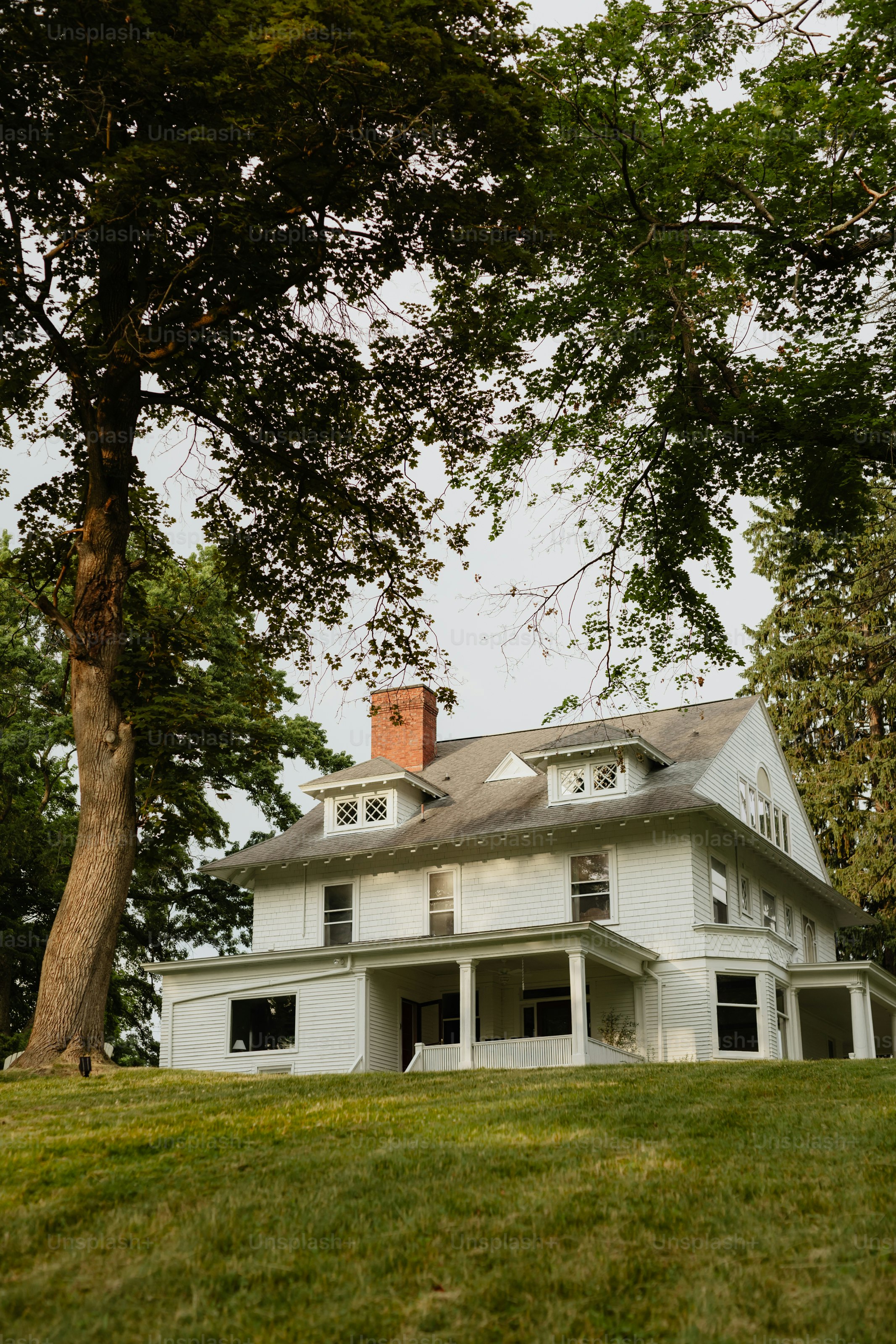 A large white house sitting on top of a lush green hillside