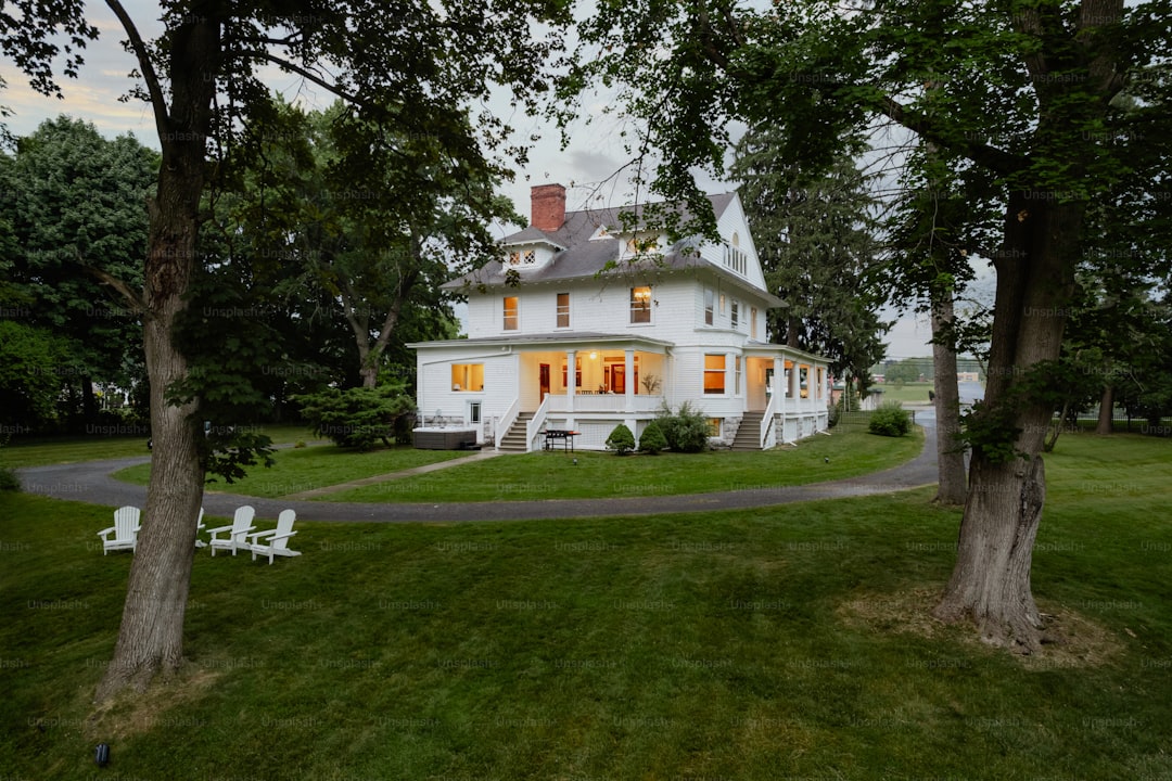 A large white house sitting on top of a lush green field
