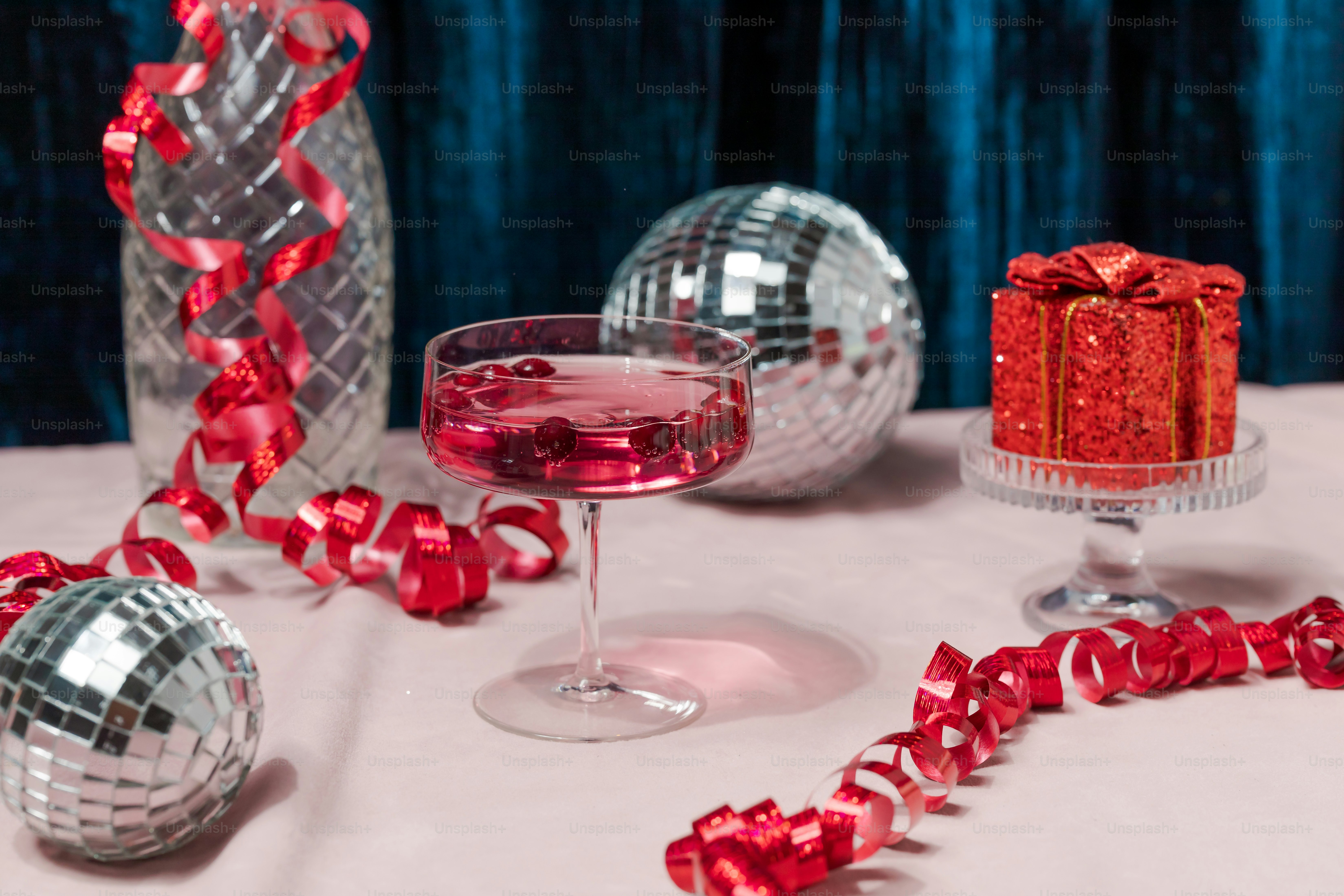 Una mesa cubierta con un pastel y una copa de vino