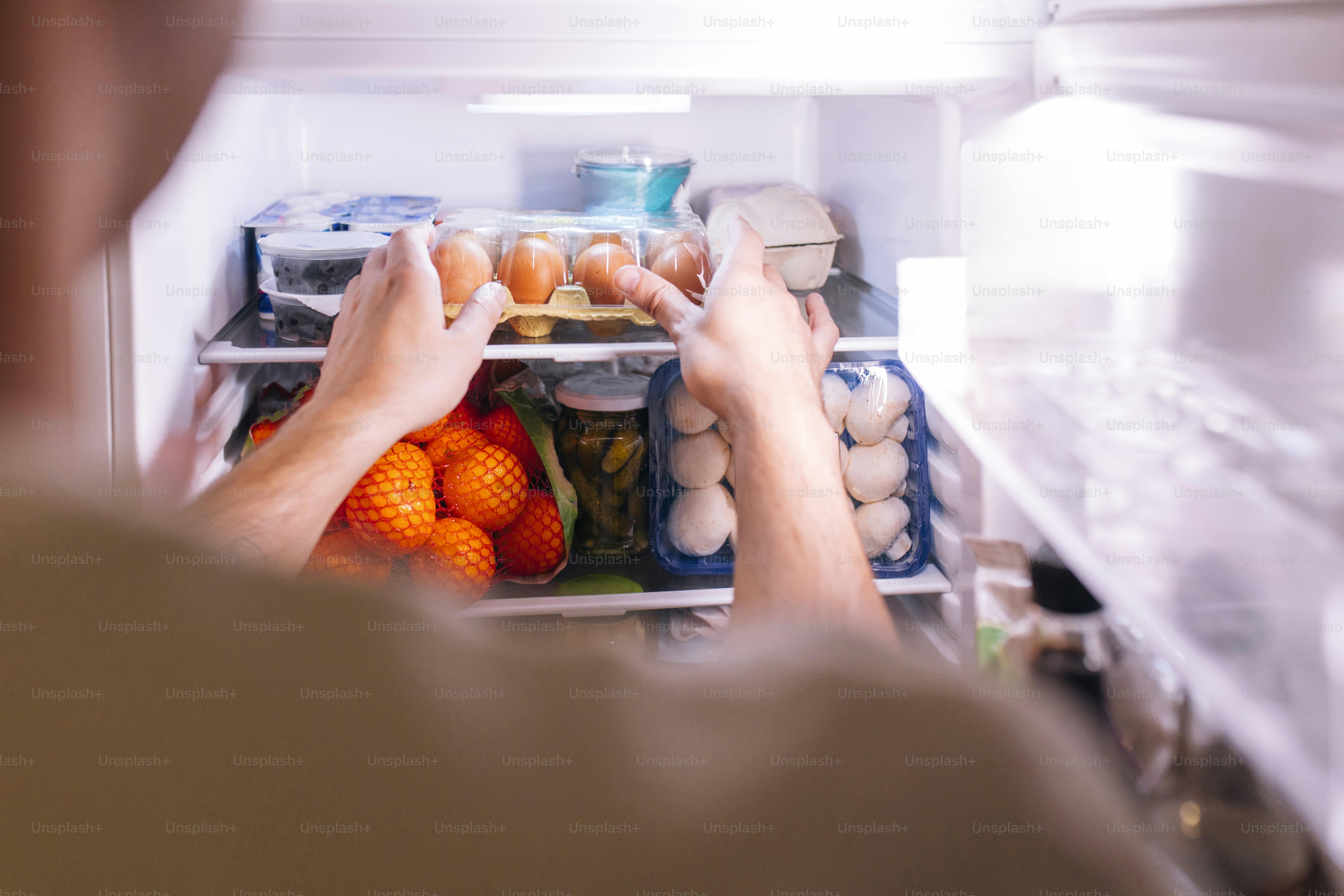 Family using connected fridge systems to organize groceries in a modern kitchen