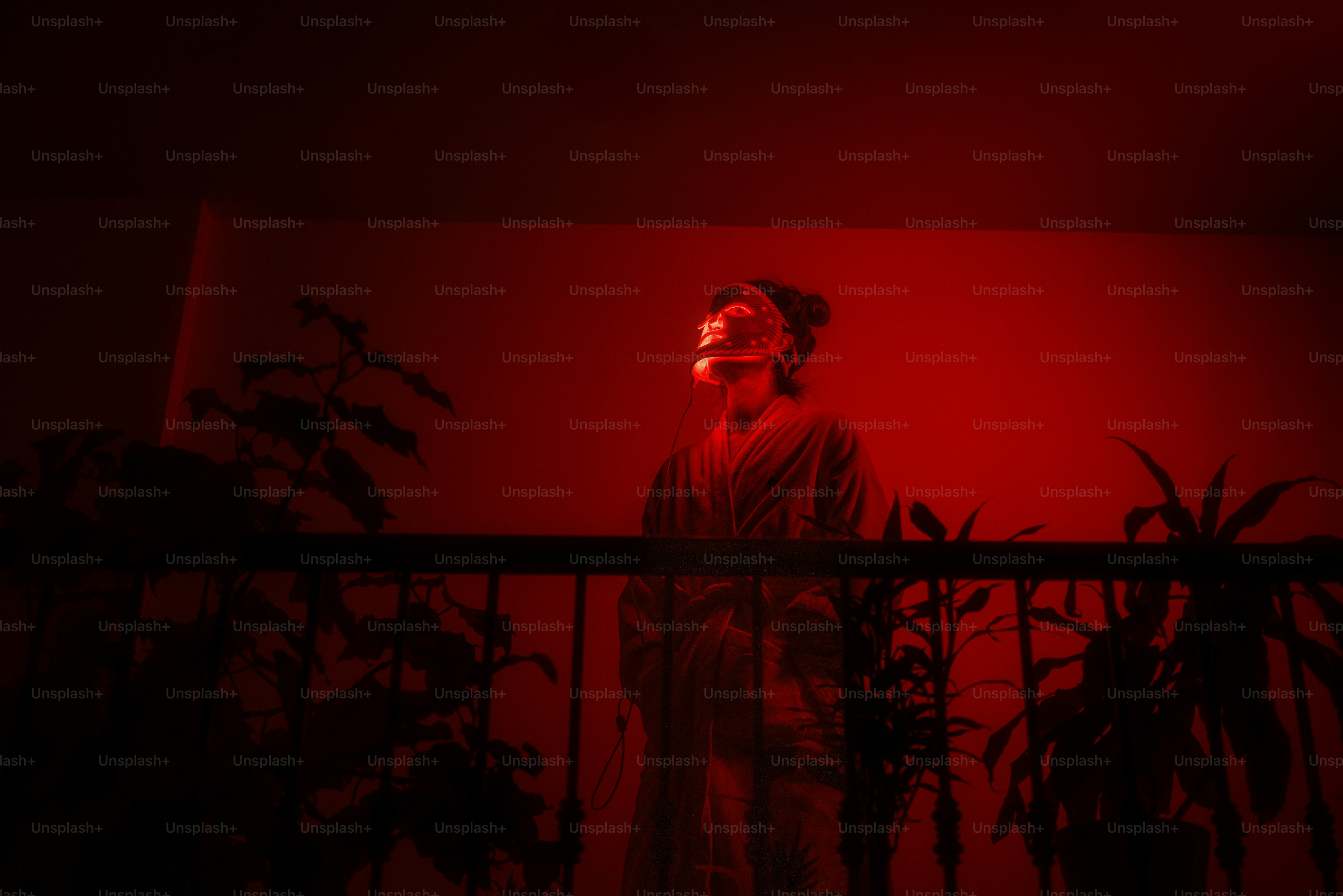 A man standing in front of a red light photo – Led mask Image on Unsplash
