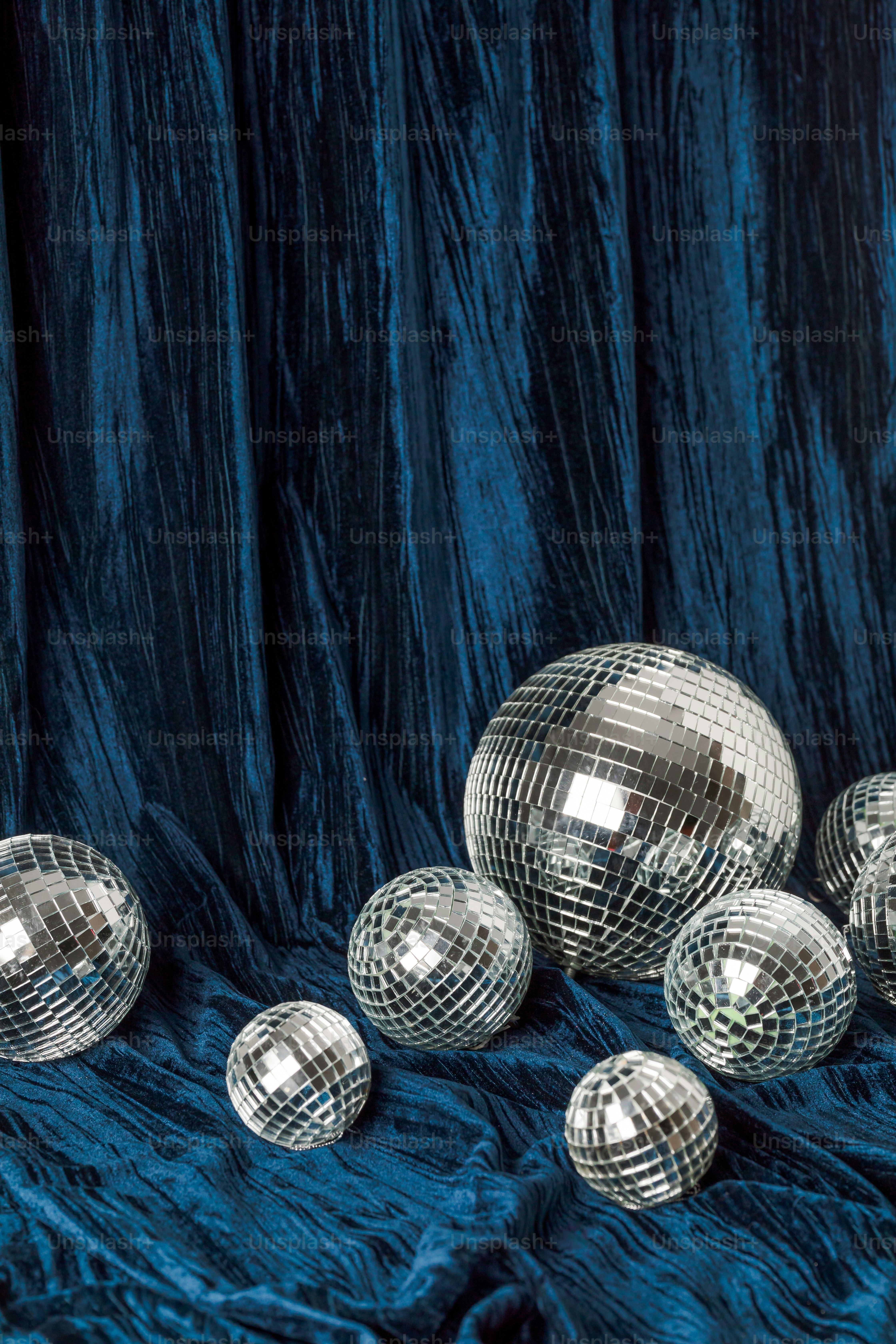 A group of shiny disco balls on a blue background