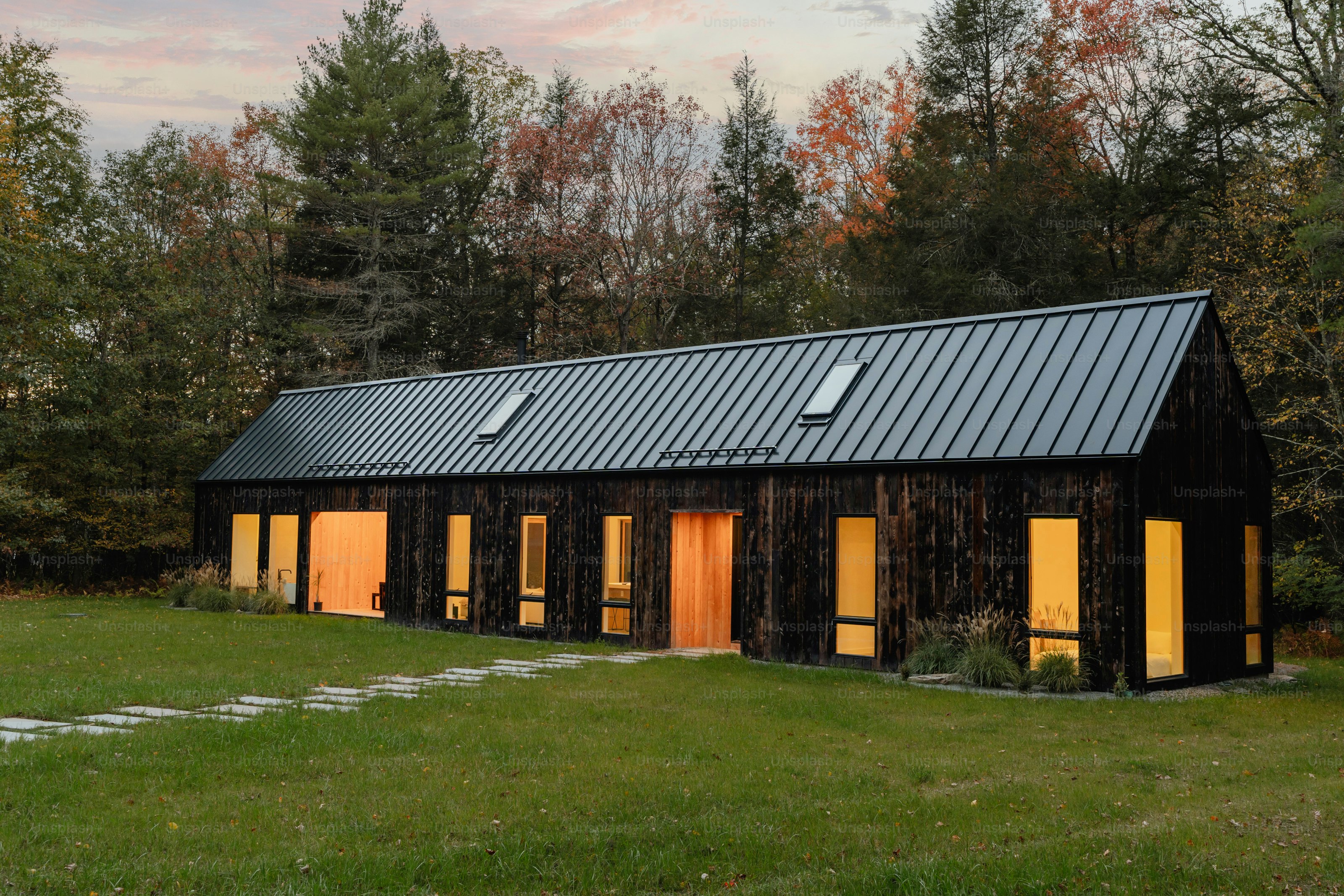 Eine kleine schwarze Hütte, die mitten auf einem Feld steht