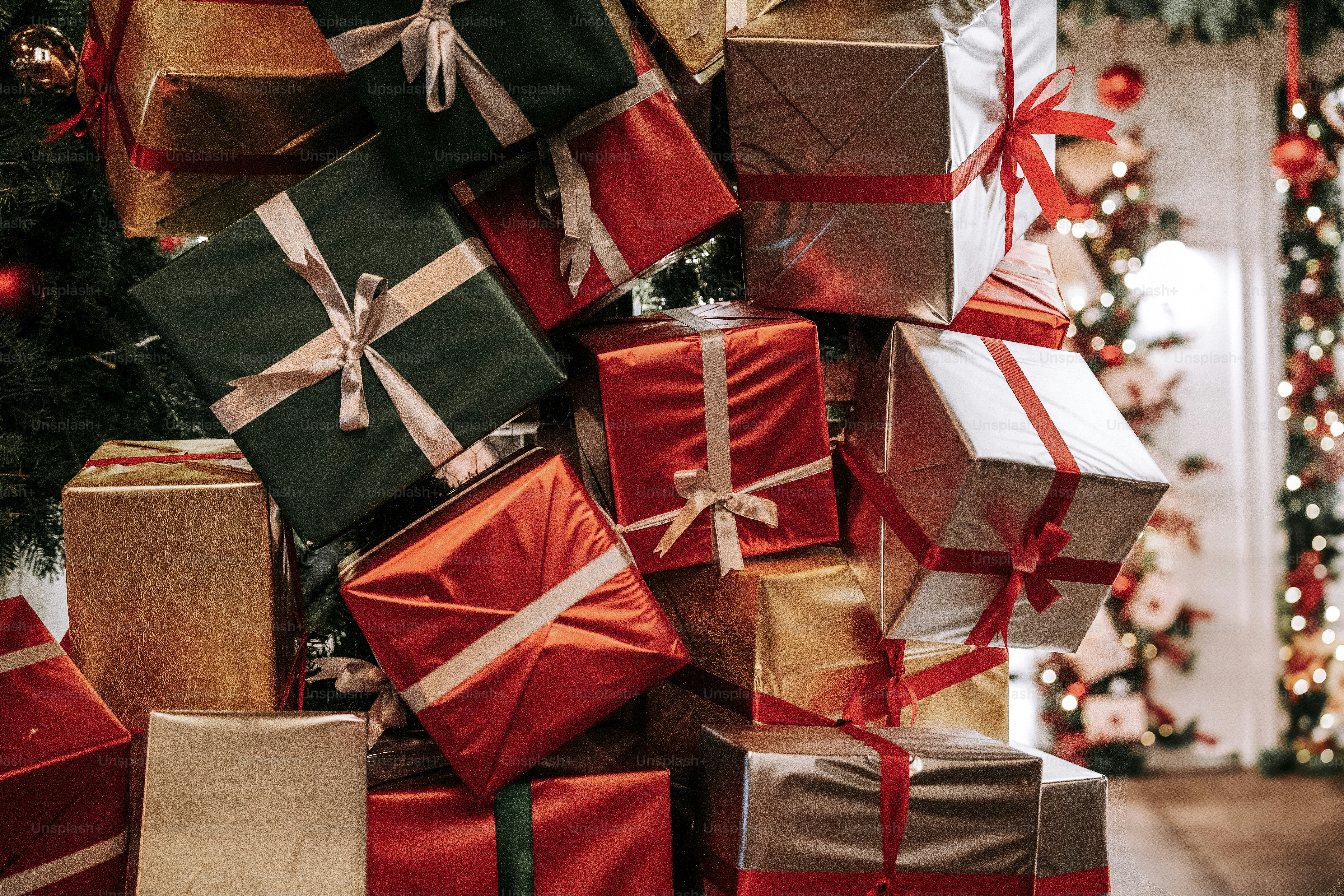 A pile of wrapped presents next to a christmas tree photo – Christmas ...