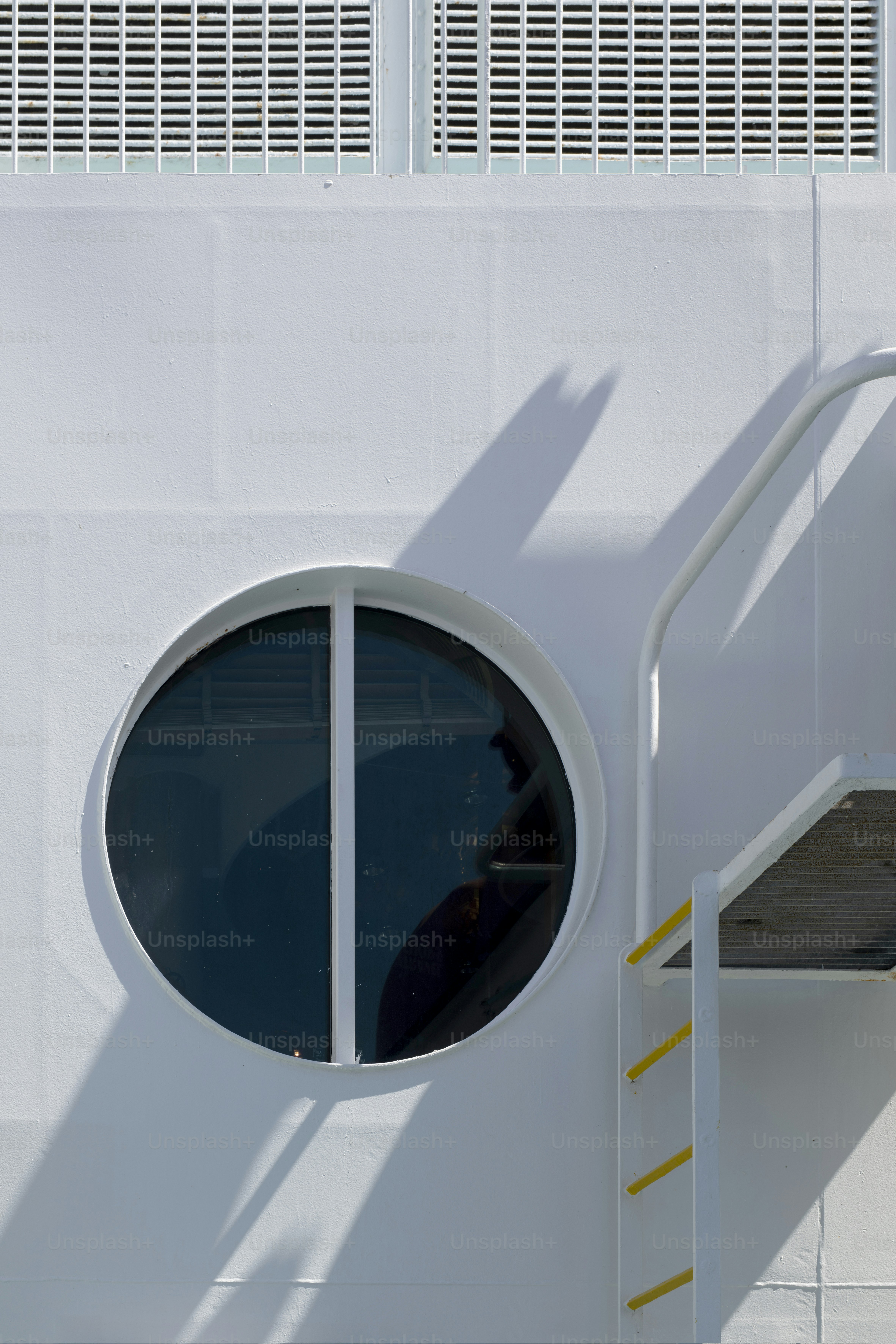 丸い窓と階段のある白い建物