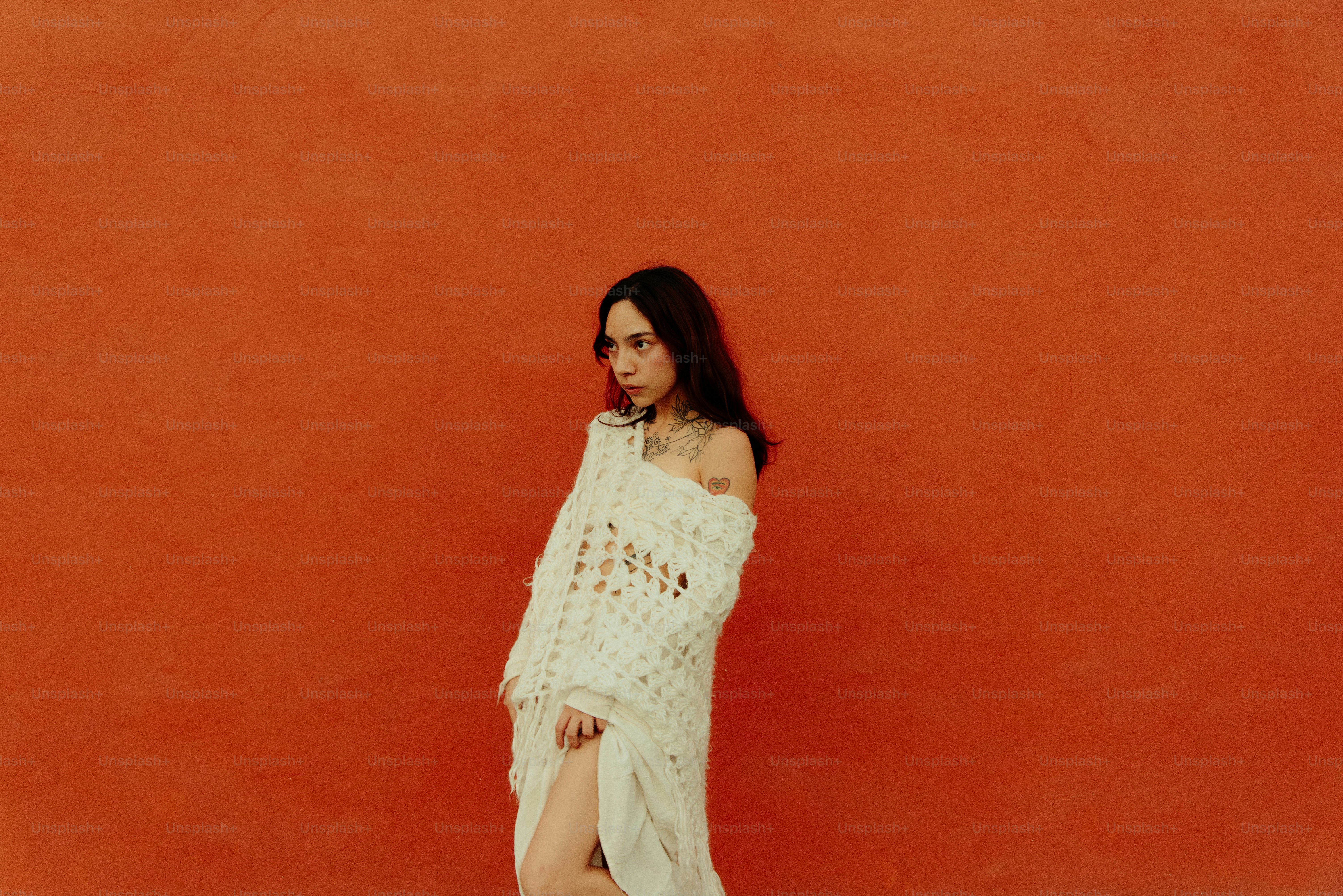 Uma mulher em pé na frente de uma parede vermelha