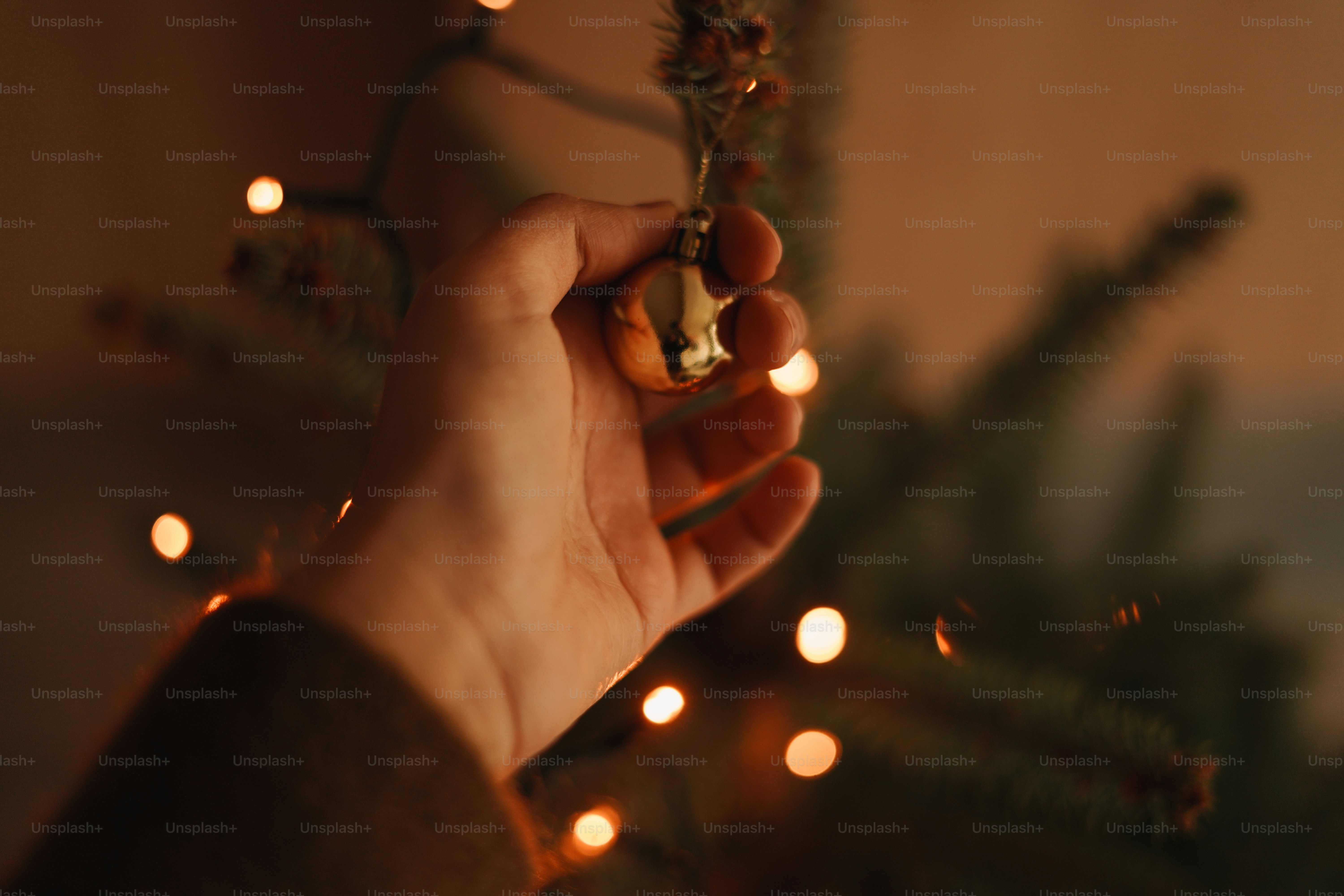 A person holding a lit christmas ornament in their hand