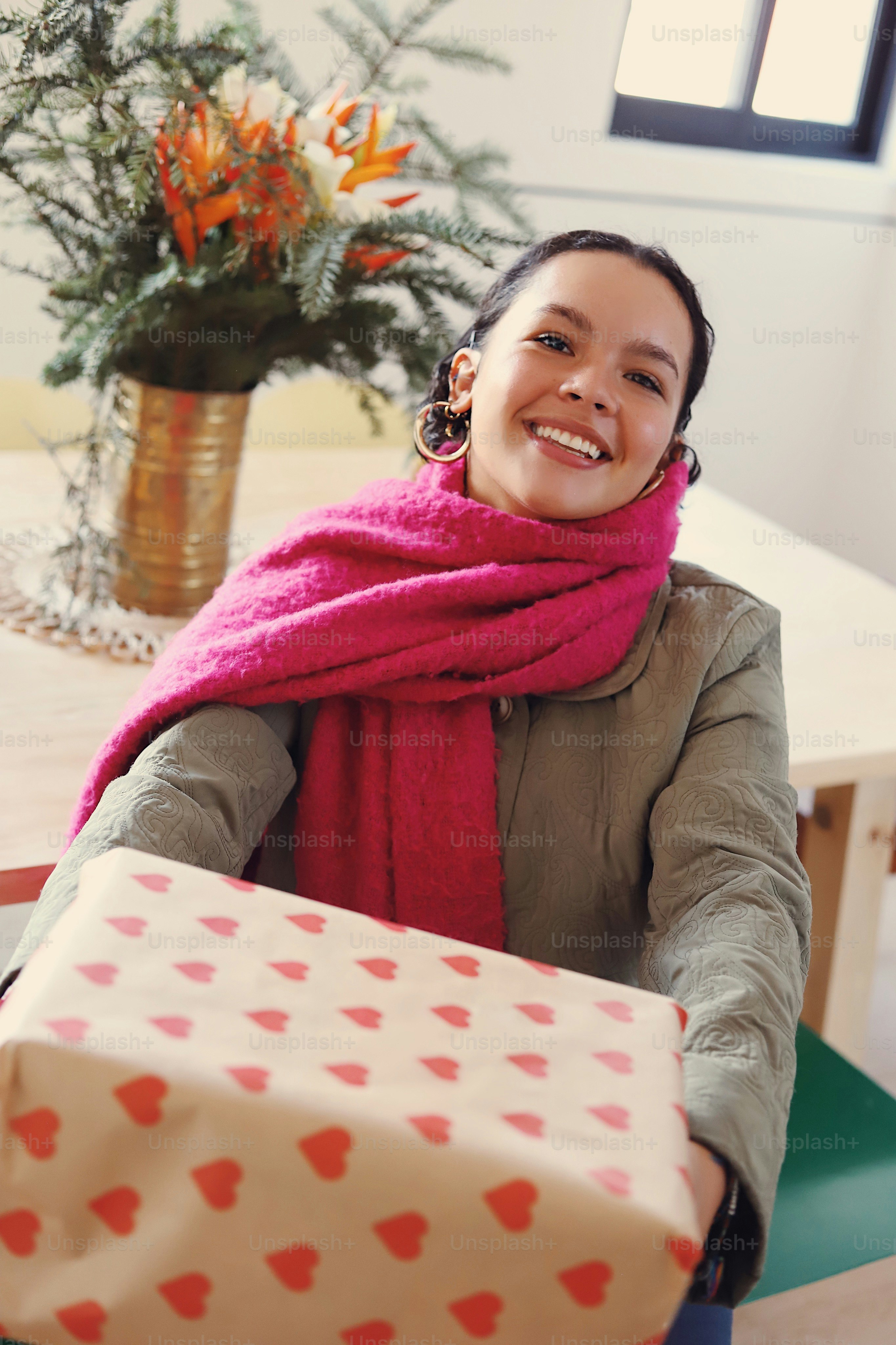 A woman sitting at a table holding a present