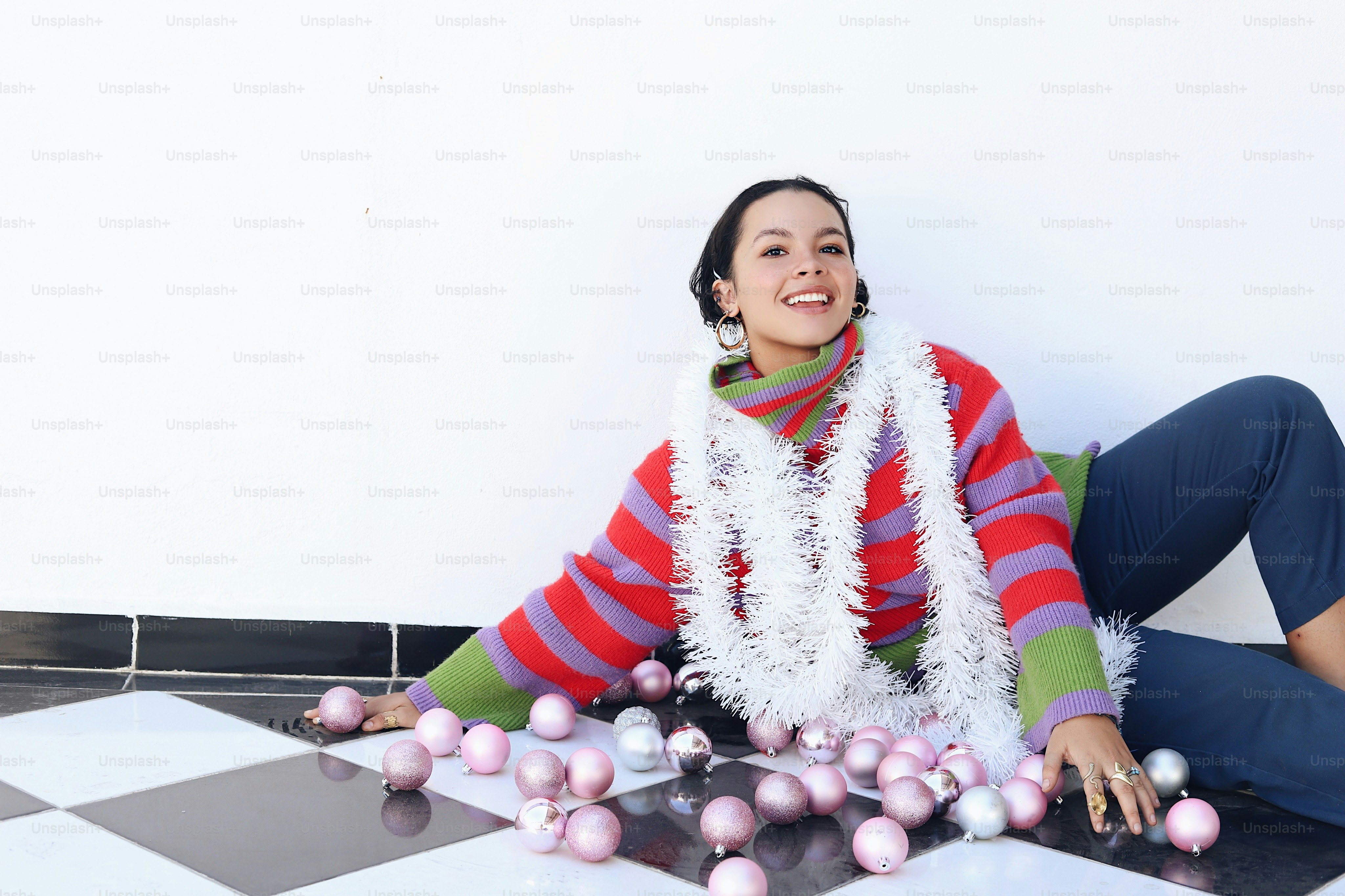 A woman sitting on the floor with a scarf around her neck