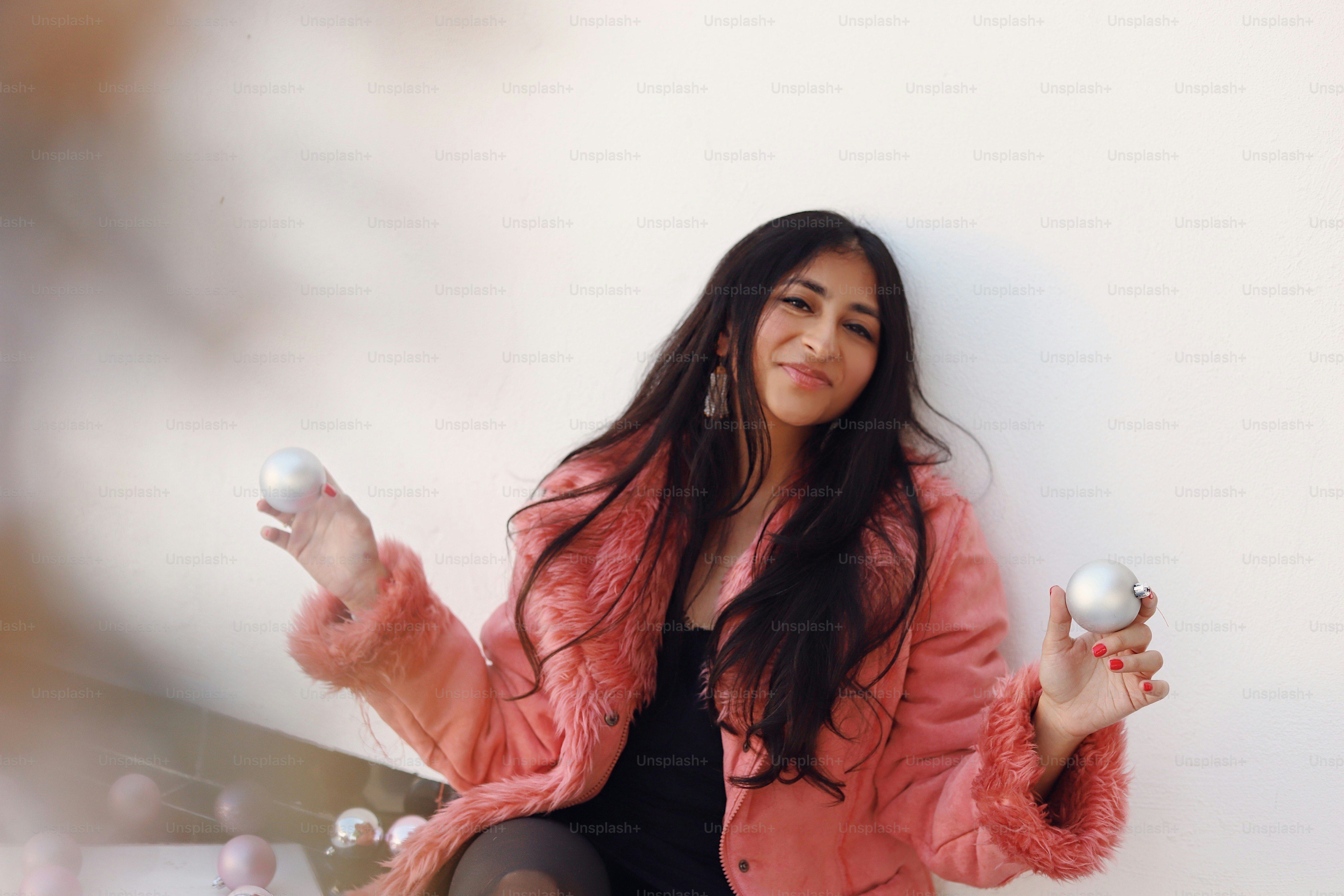 A woman in a black dress and a pink jacket