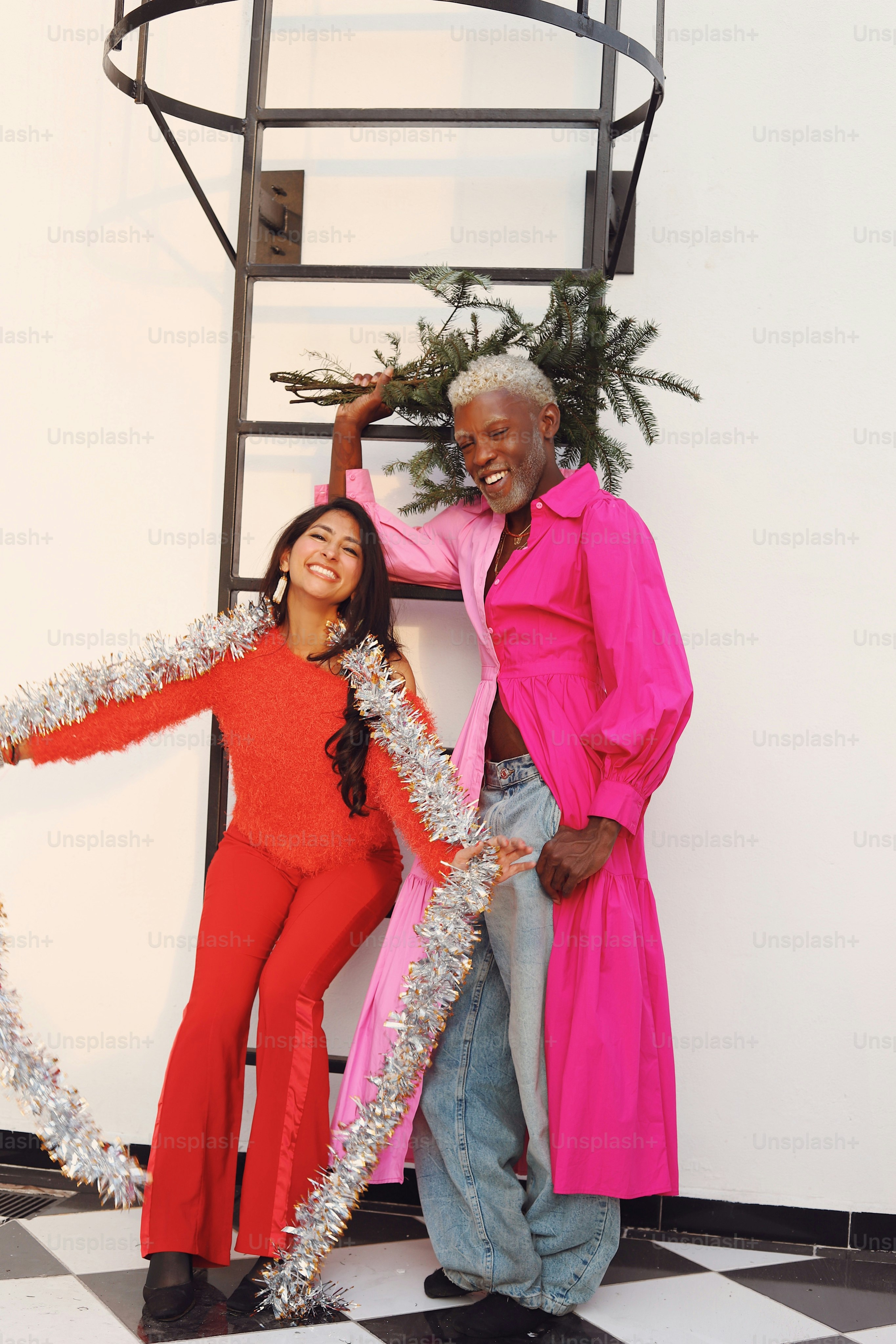 A man and a woman standing in front of a spiral staircase