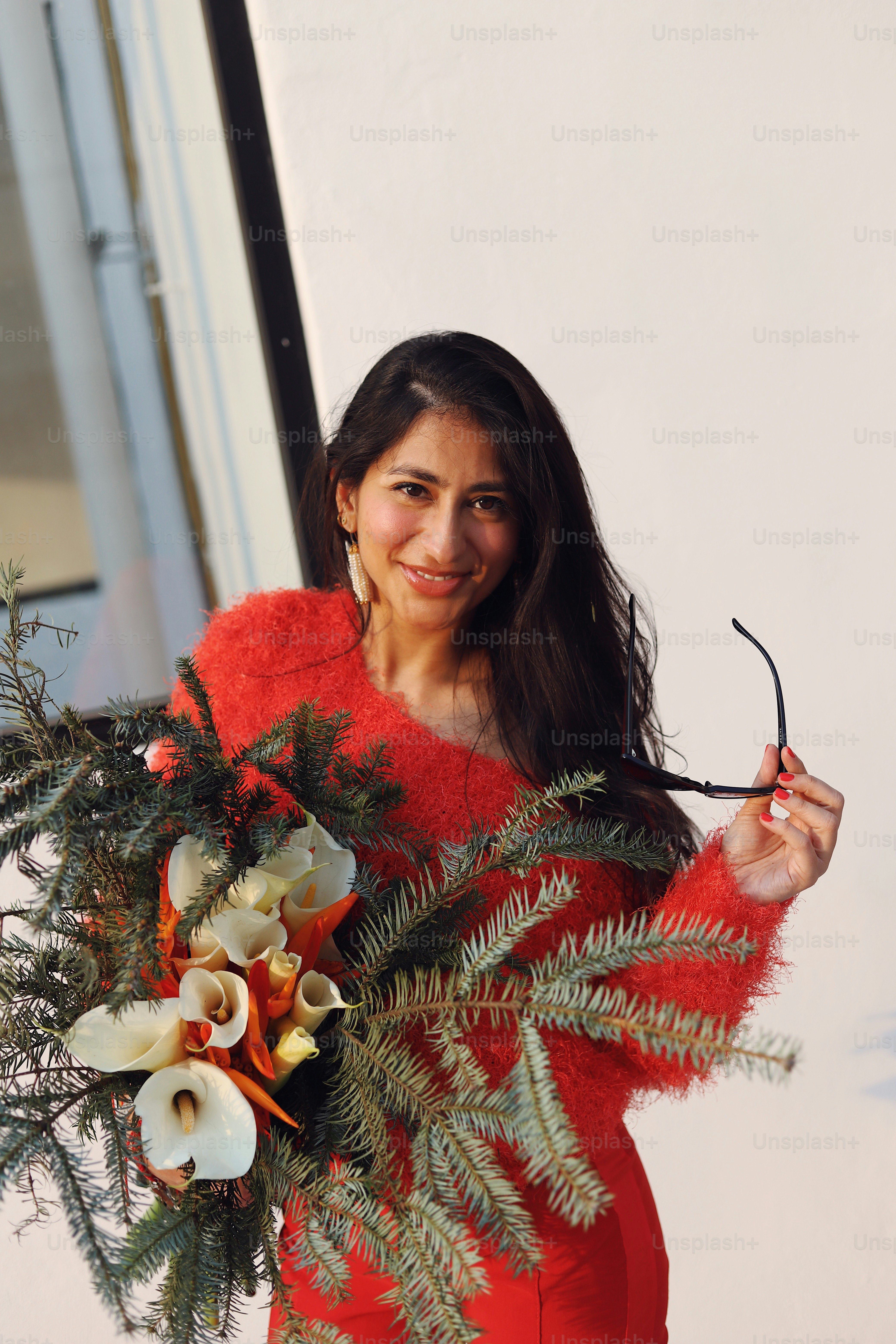 A woman in a red dress holding a bouquet of flowers