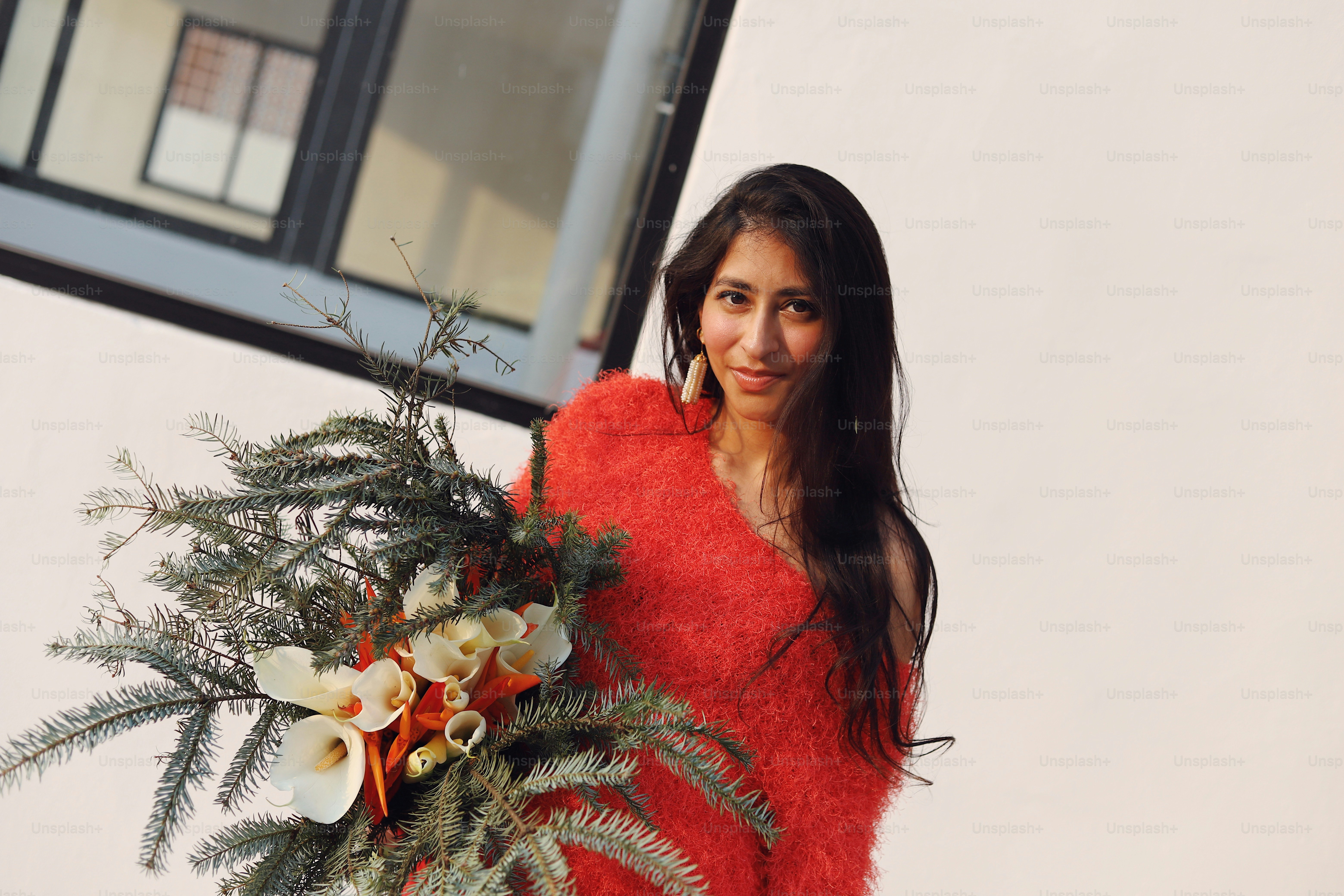 A woman in a red sweater holding a bouquet of flowers photo – Model ...