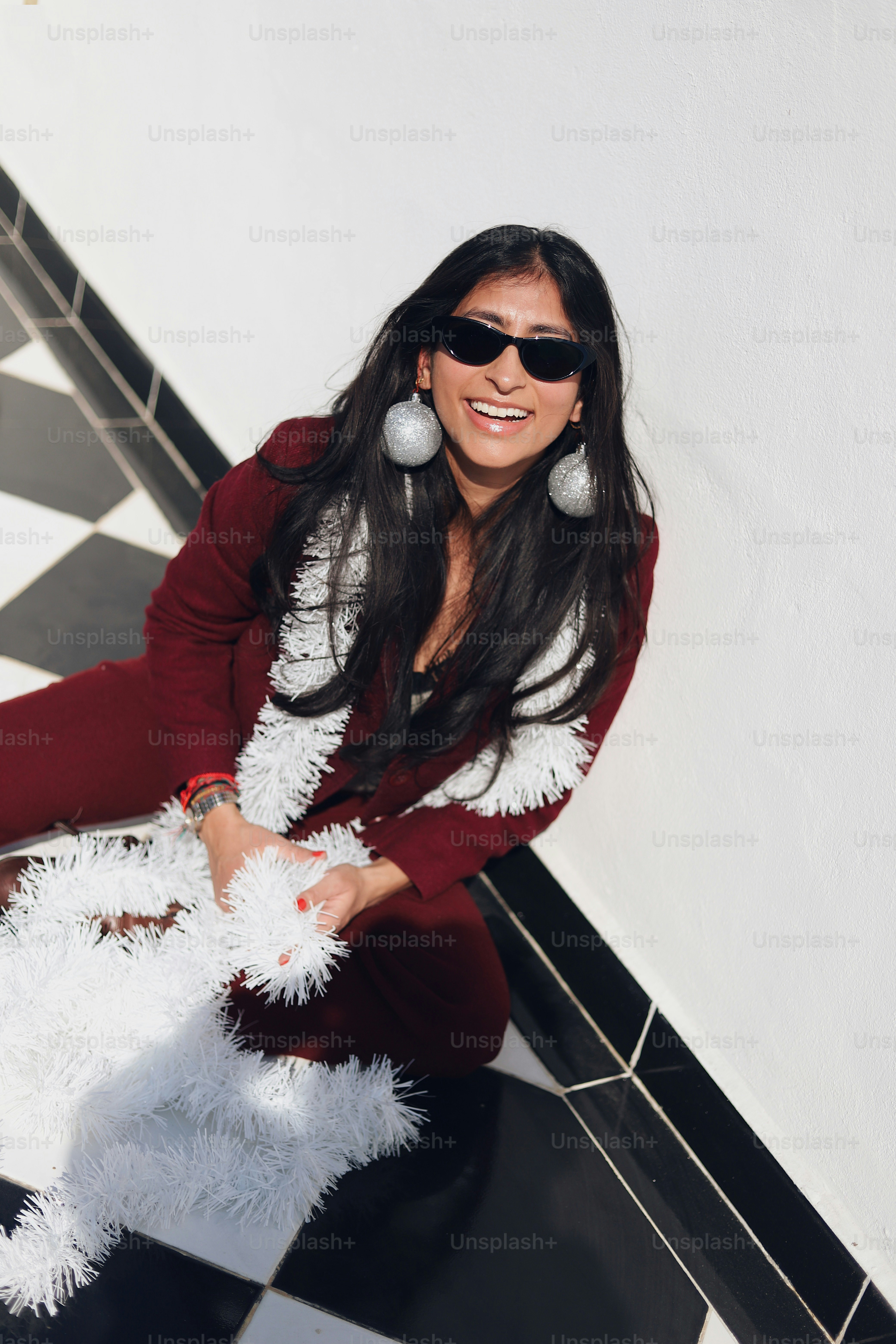 A woman sitting on a black and white checkered floor