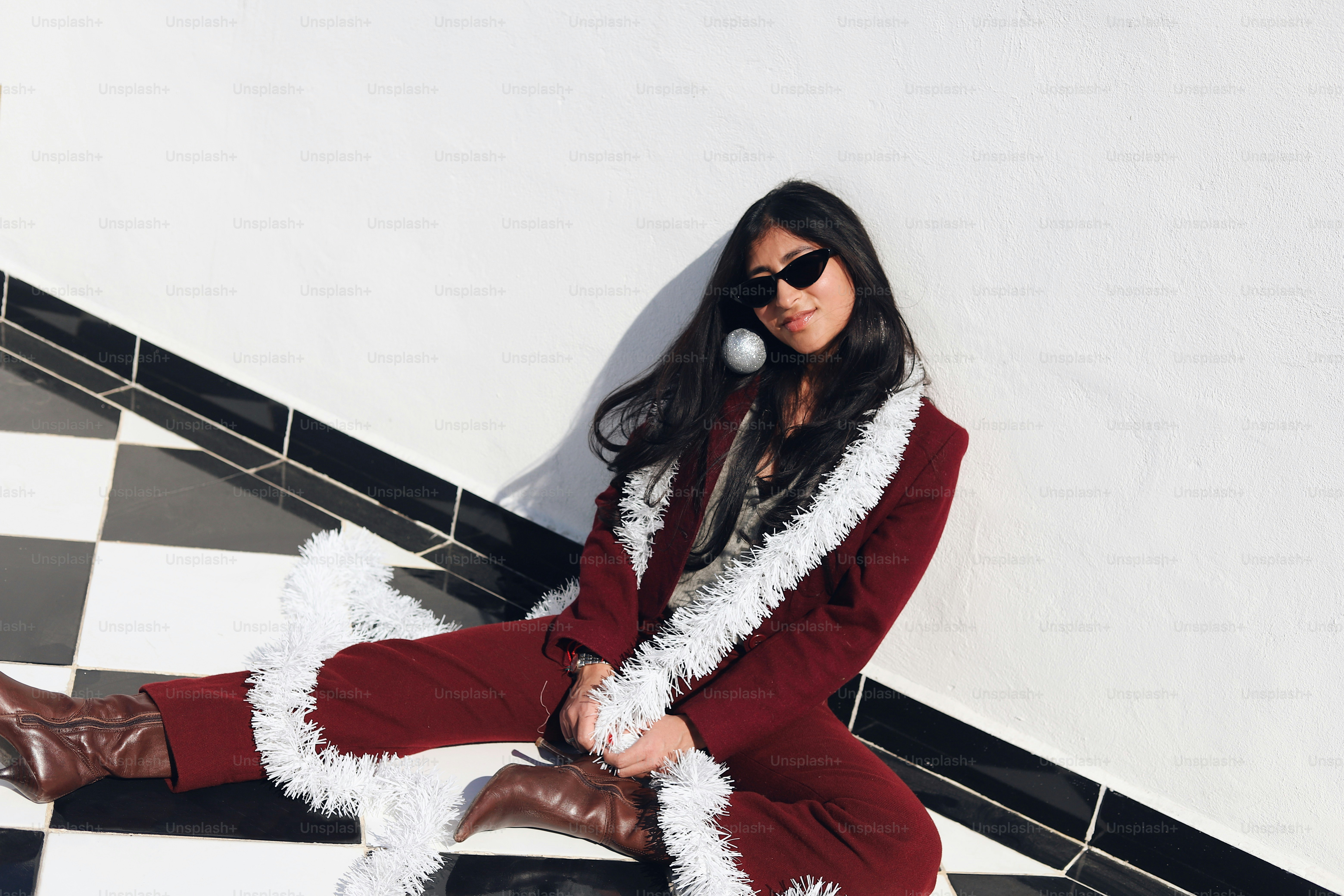 A woman in a red and white outfit sitting on a black and white checkered