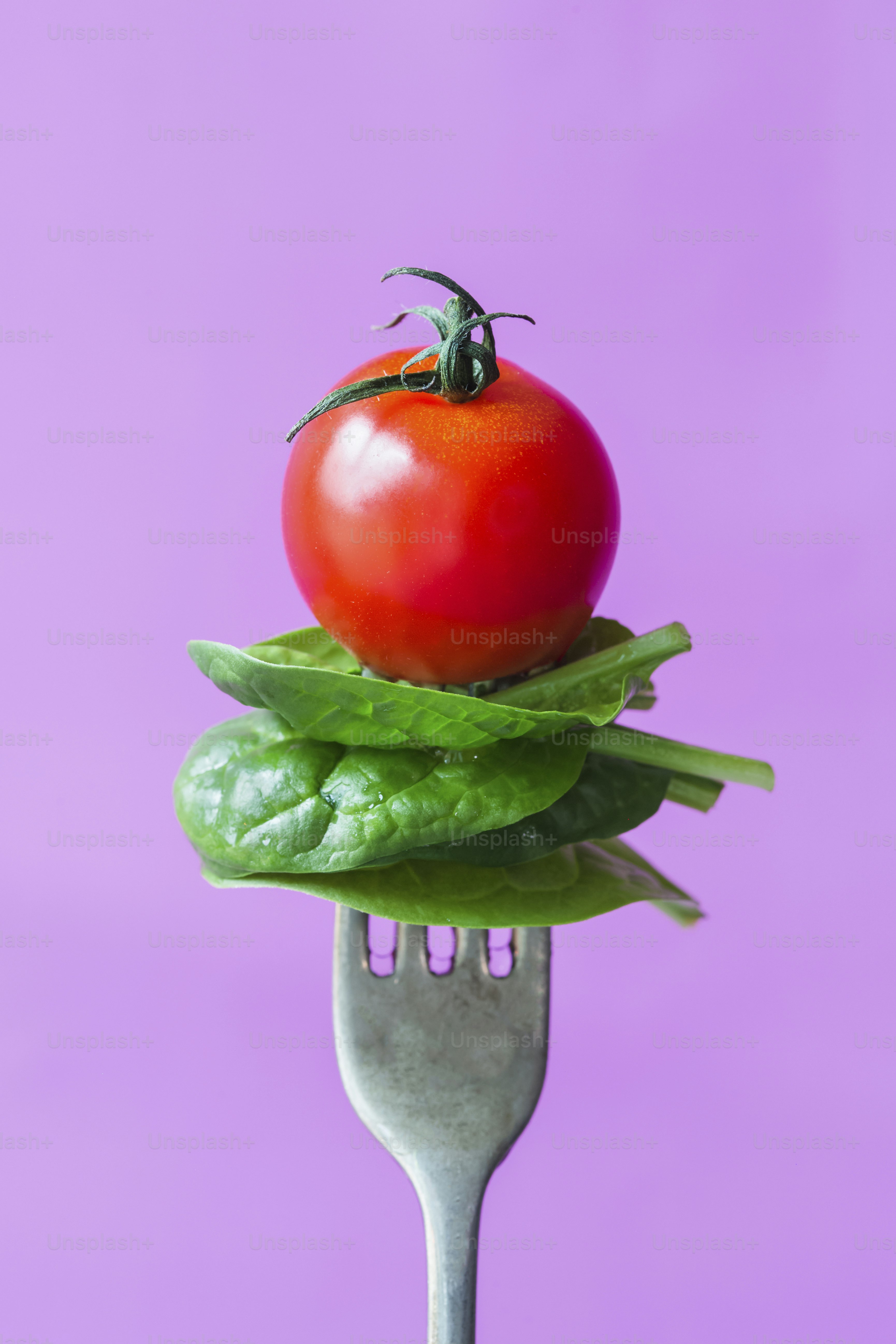 A fork with a tomato on top of it