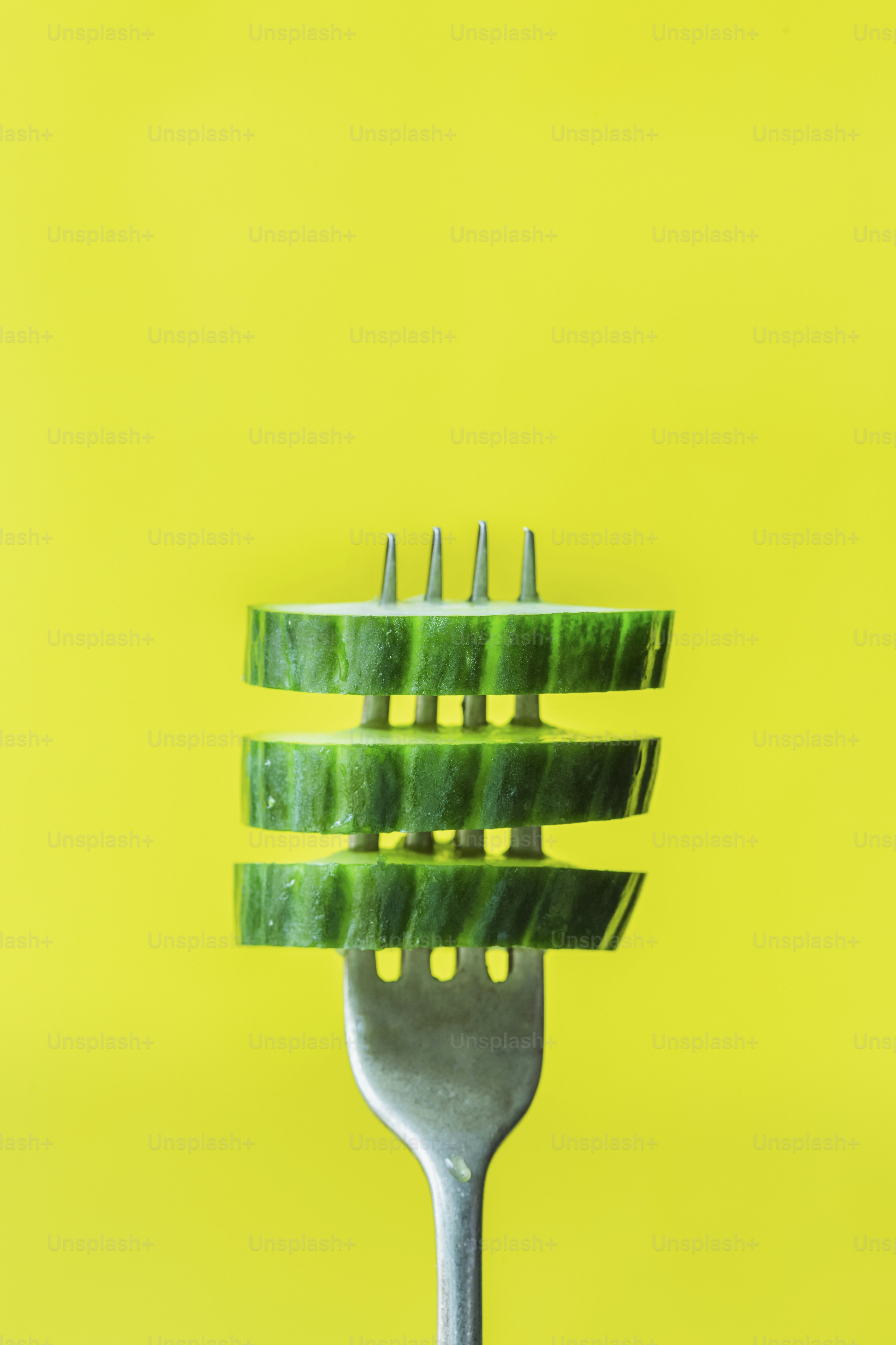 A close up of a fork on a yellow background