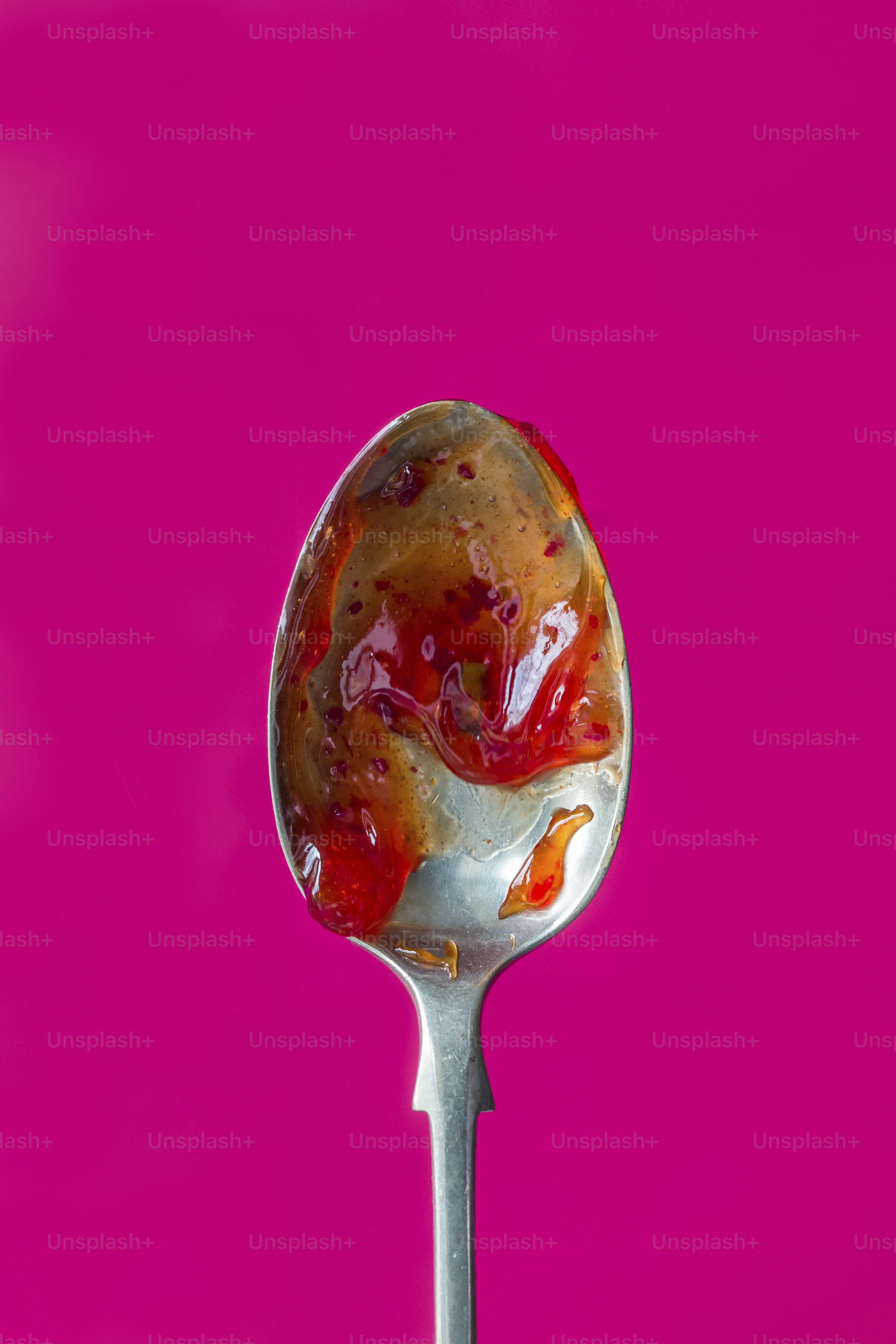 A spoon with a spoon full of jelly on it