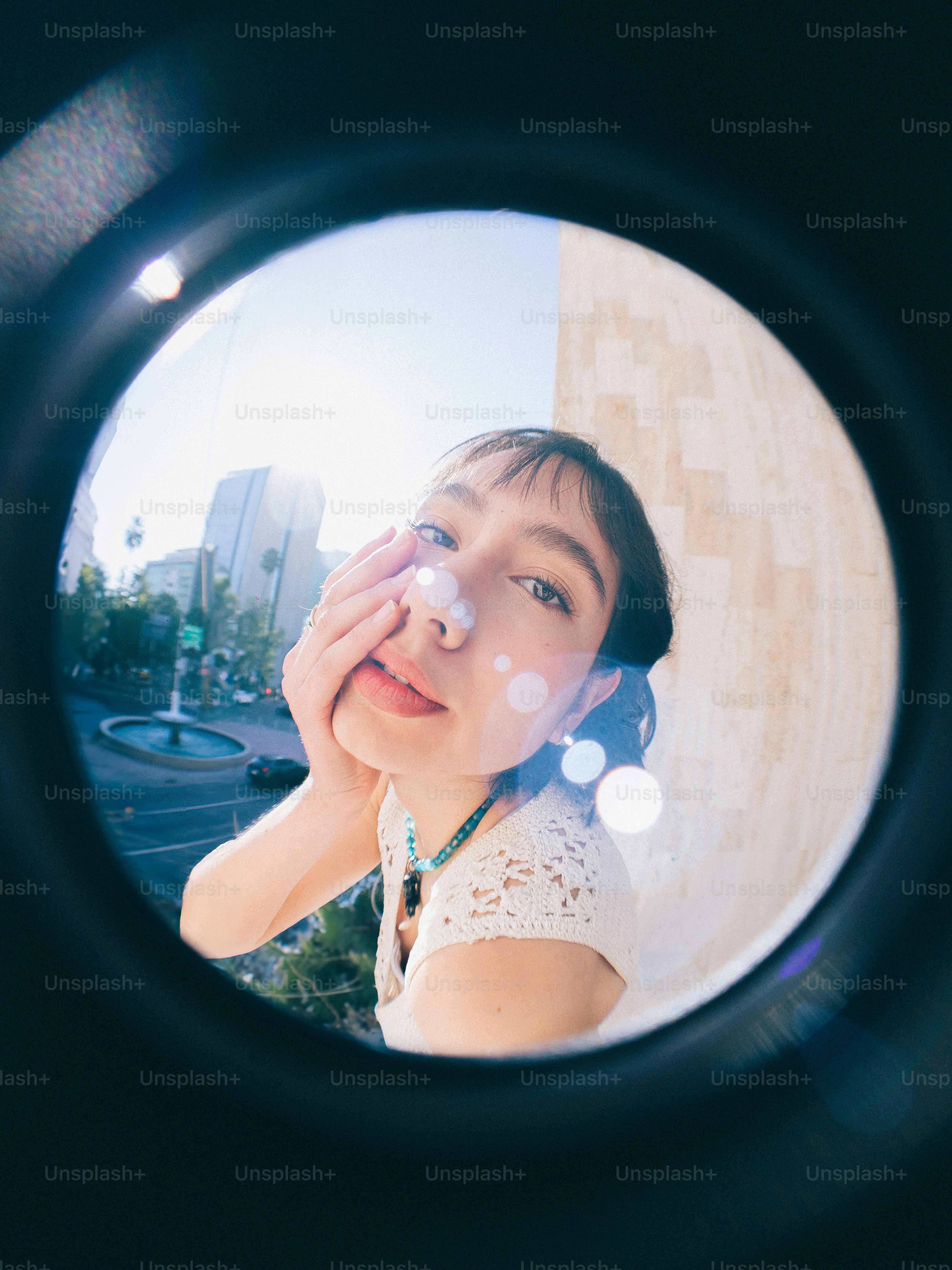 A woman looking through a lens at a building