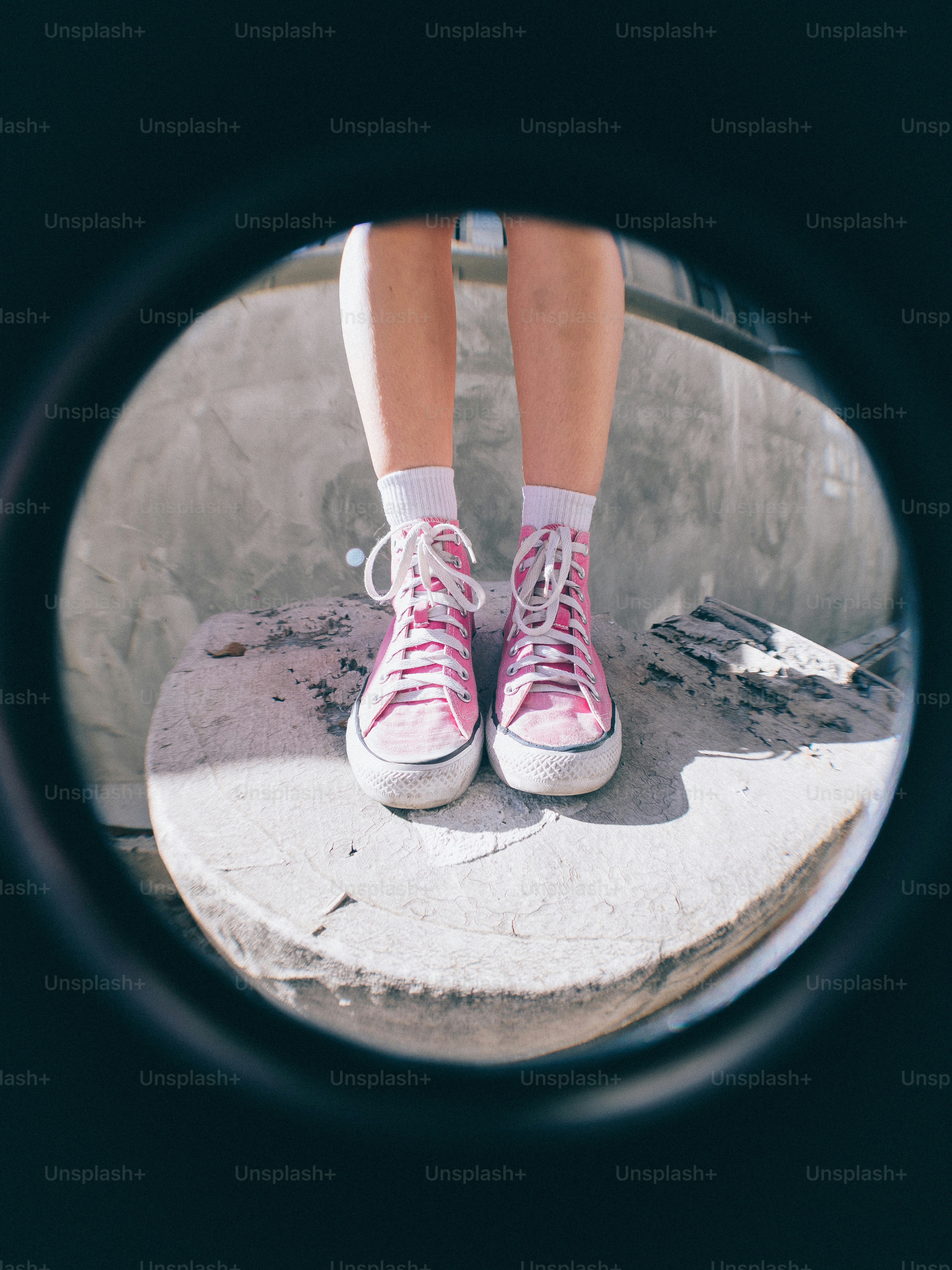 Los pies de una persona se ven a través de un agujero en el concreto