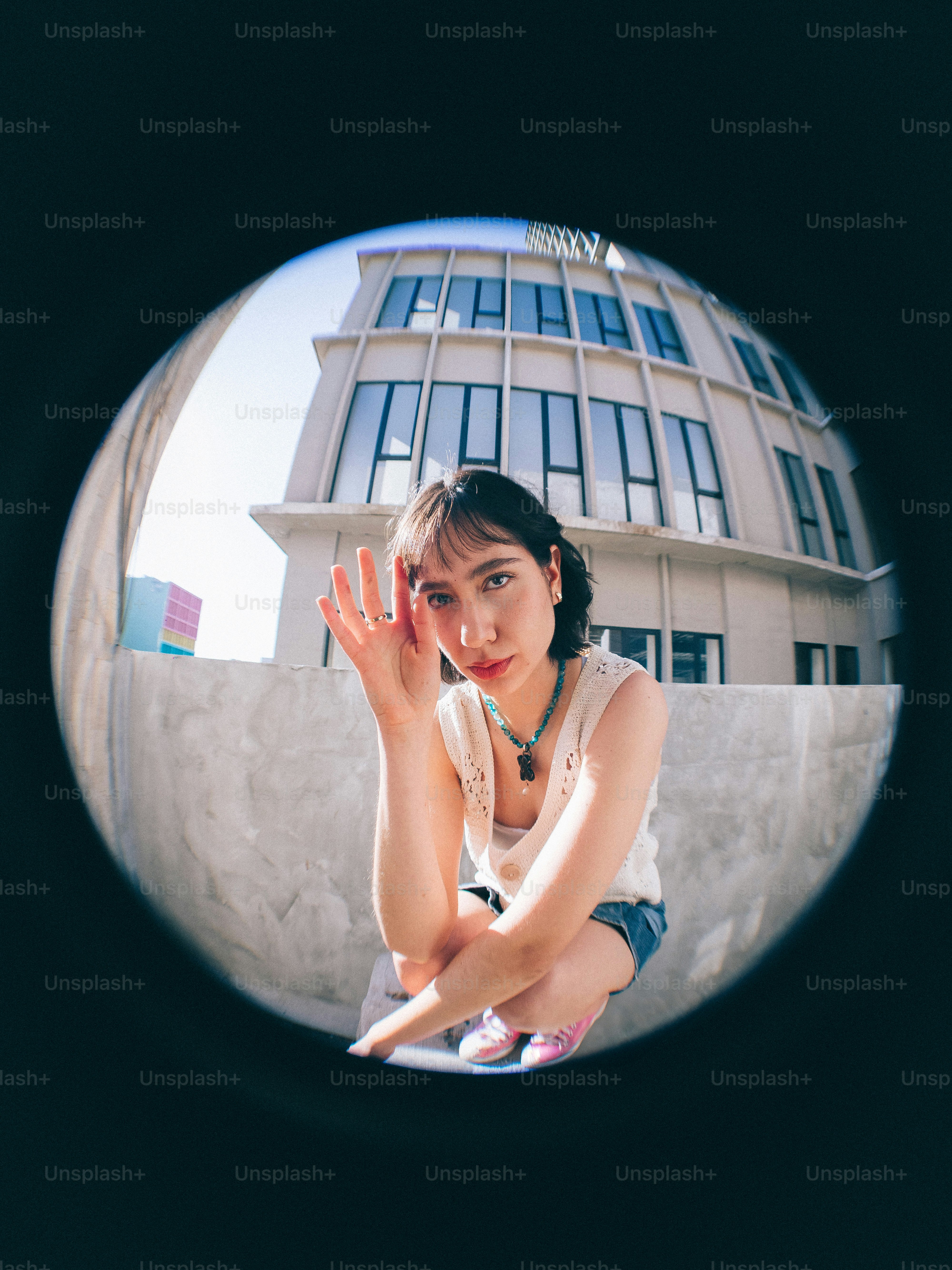 A woman sitting on the ground in front of a building