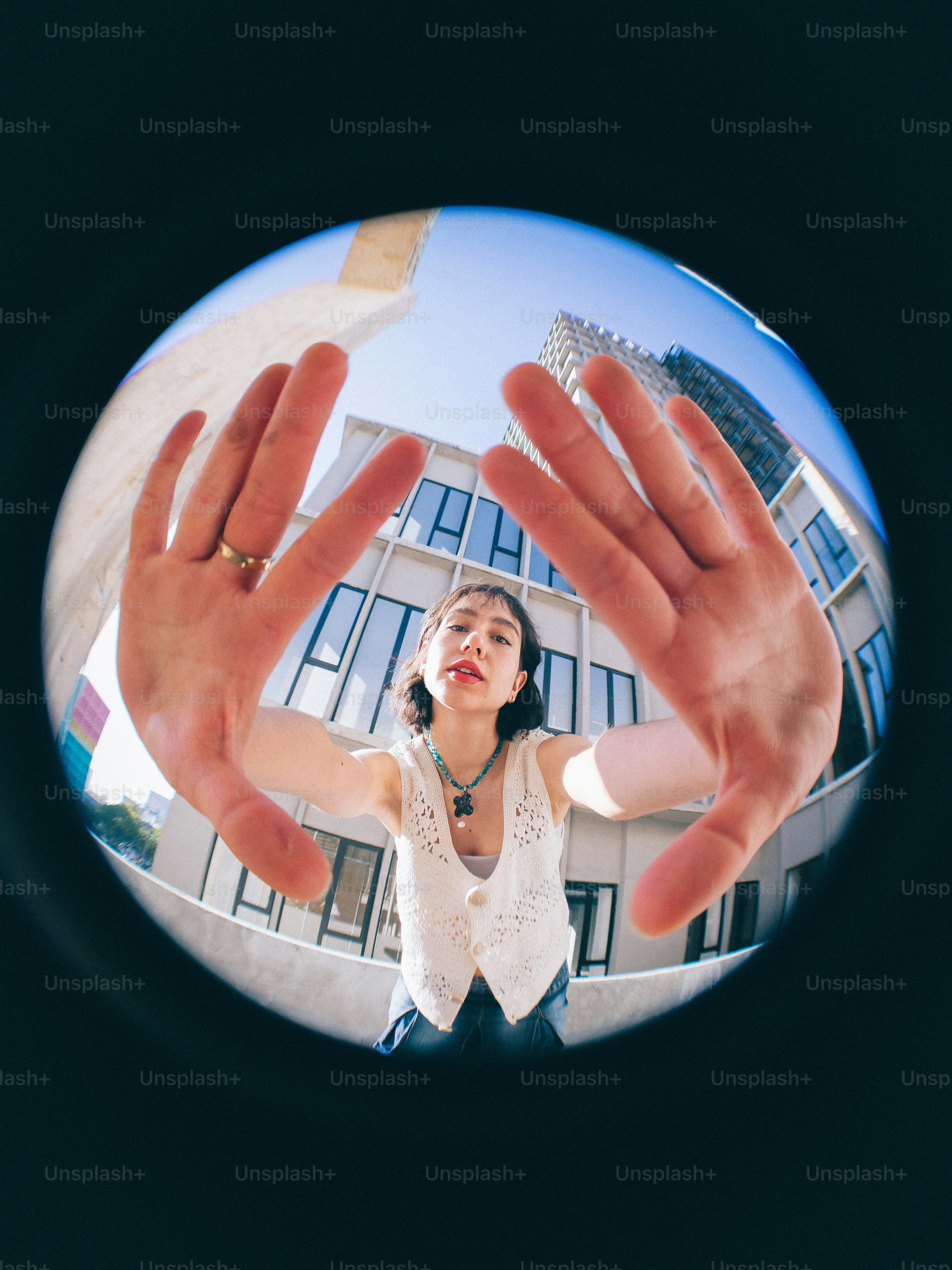 A woman holding her hands up in front of a building