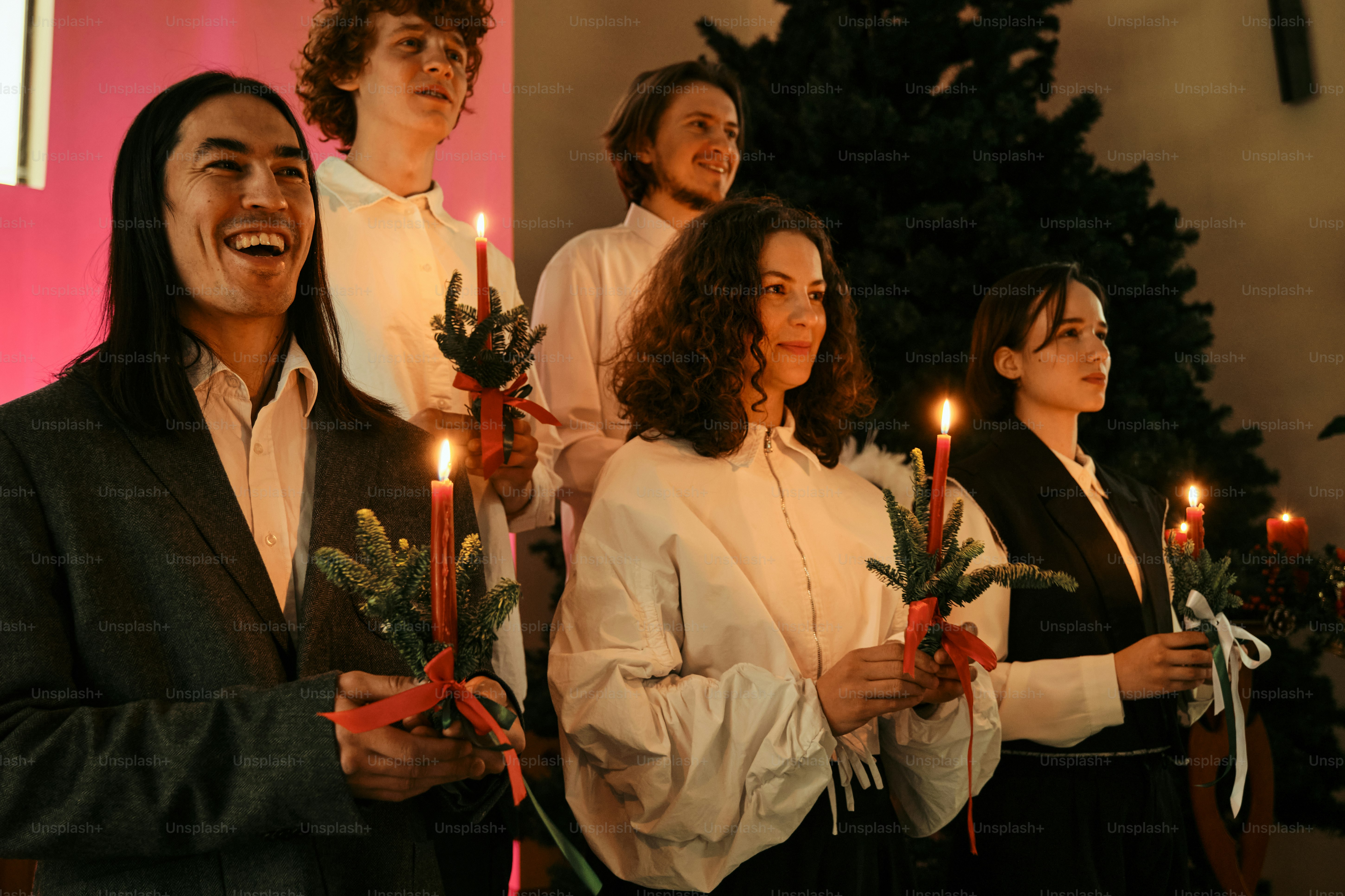 A group of people standing next to each other holding candles