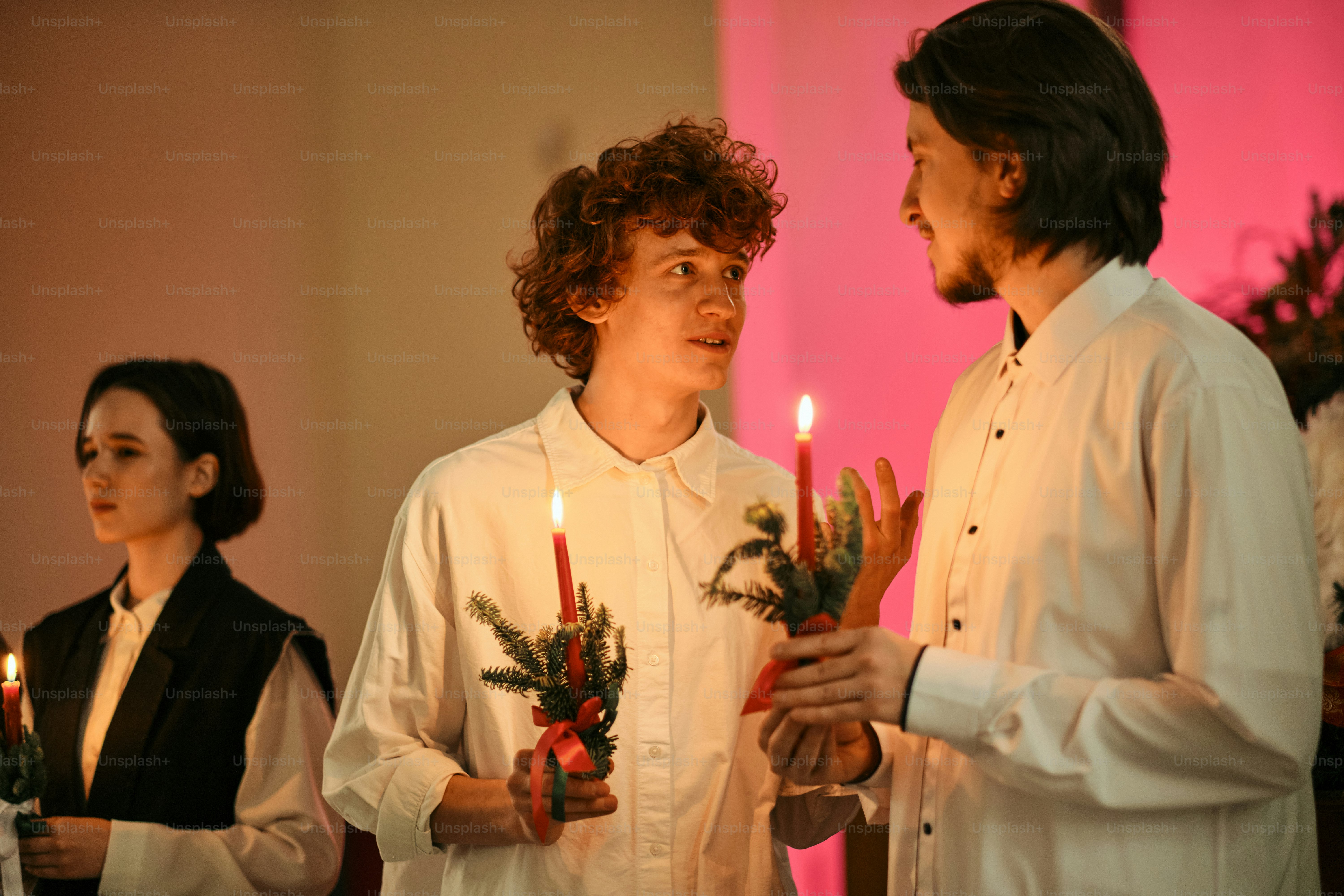 Um grupo de pessoas em pé um ao lado do outro segurando velas