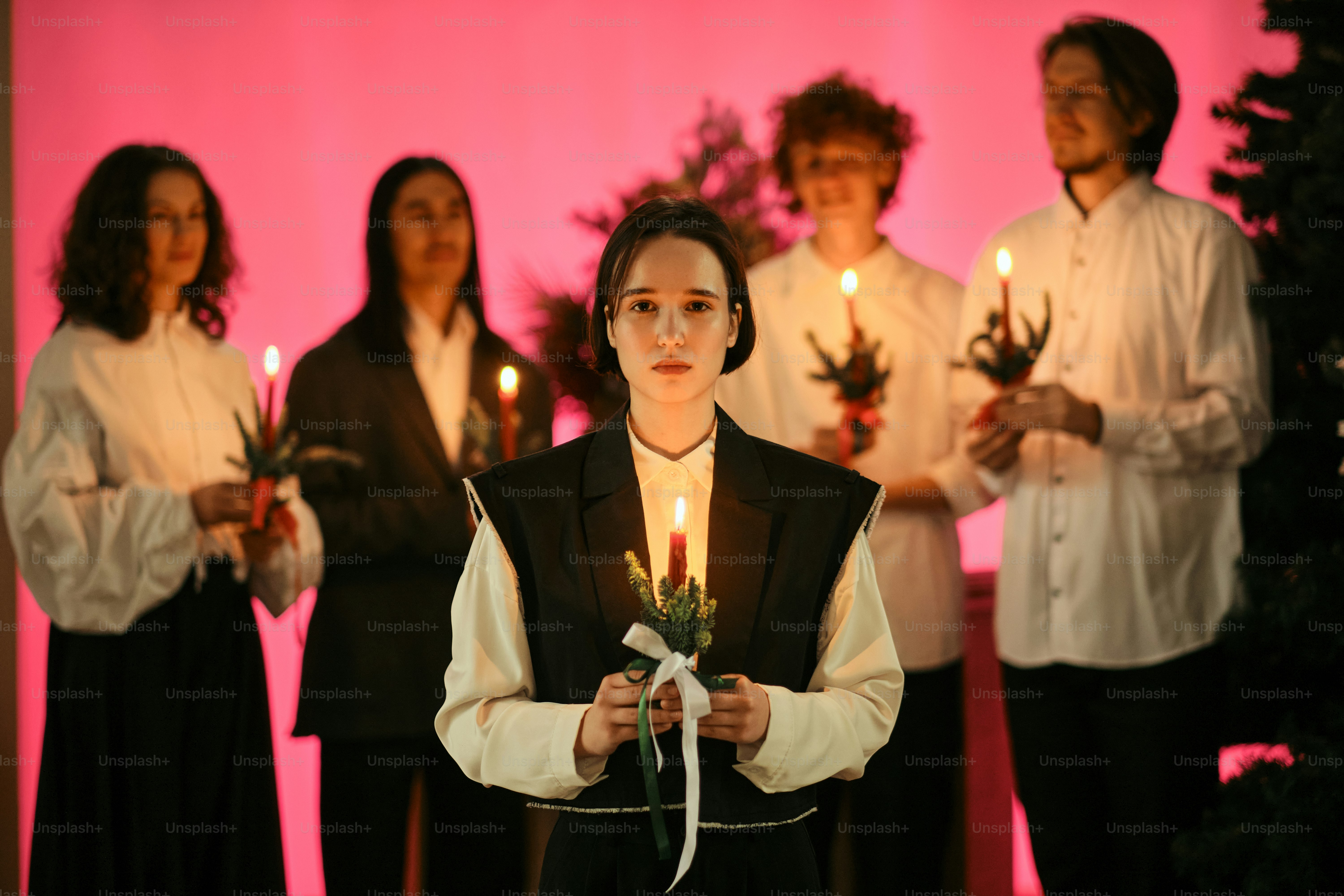 A woman holding a lit candle in front of a group of people
