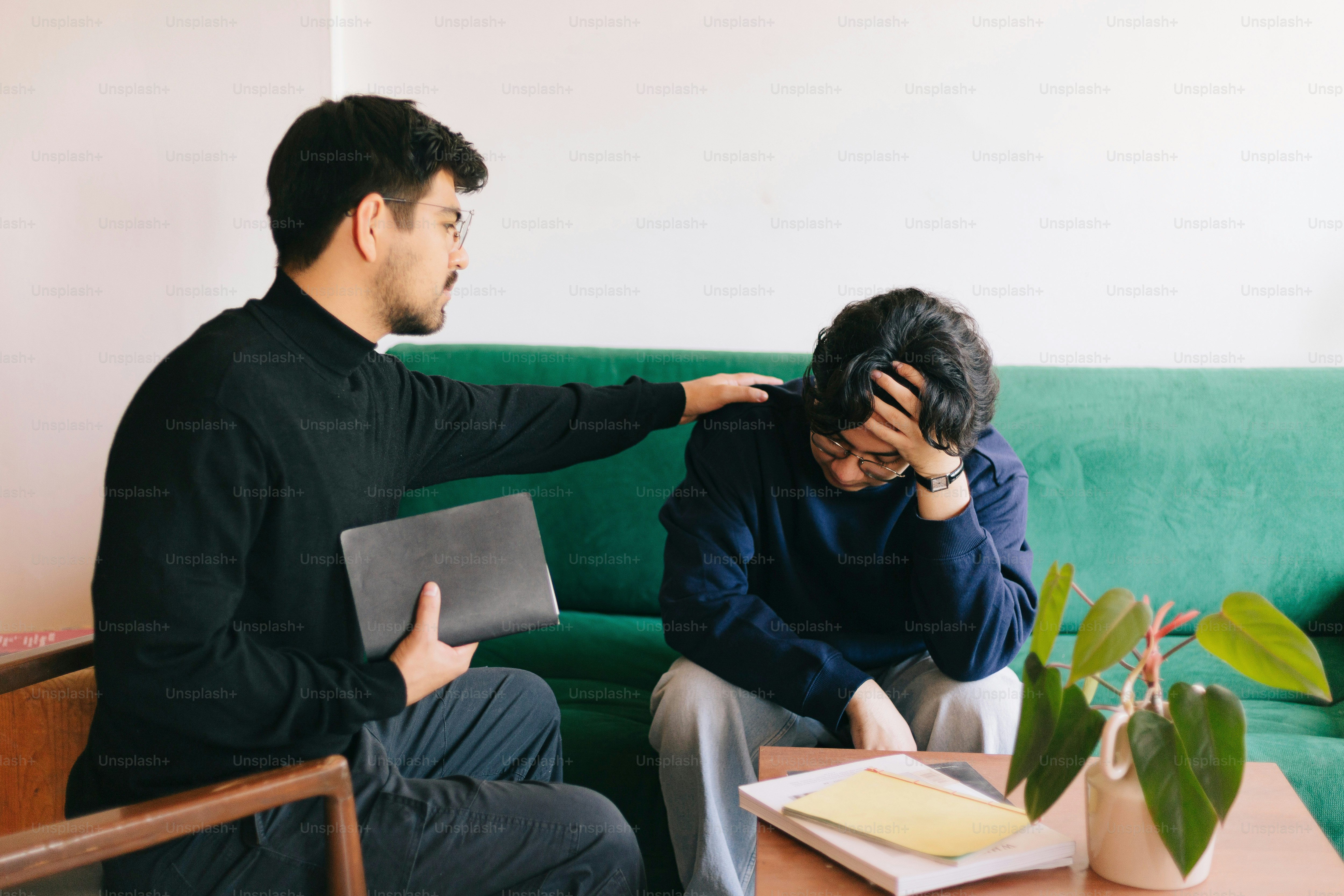 A man and a woman sitting on a green couch