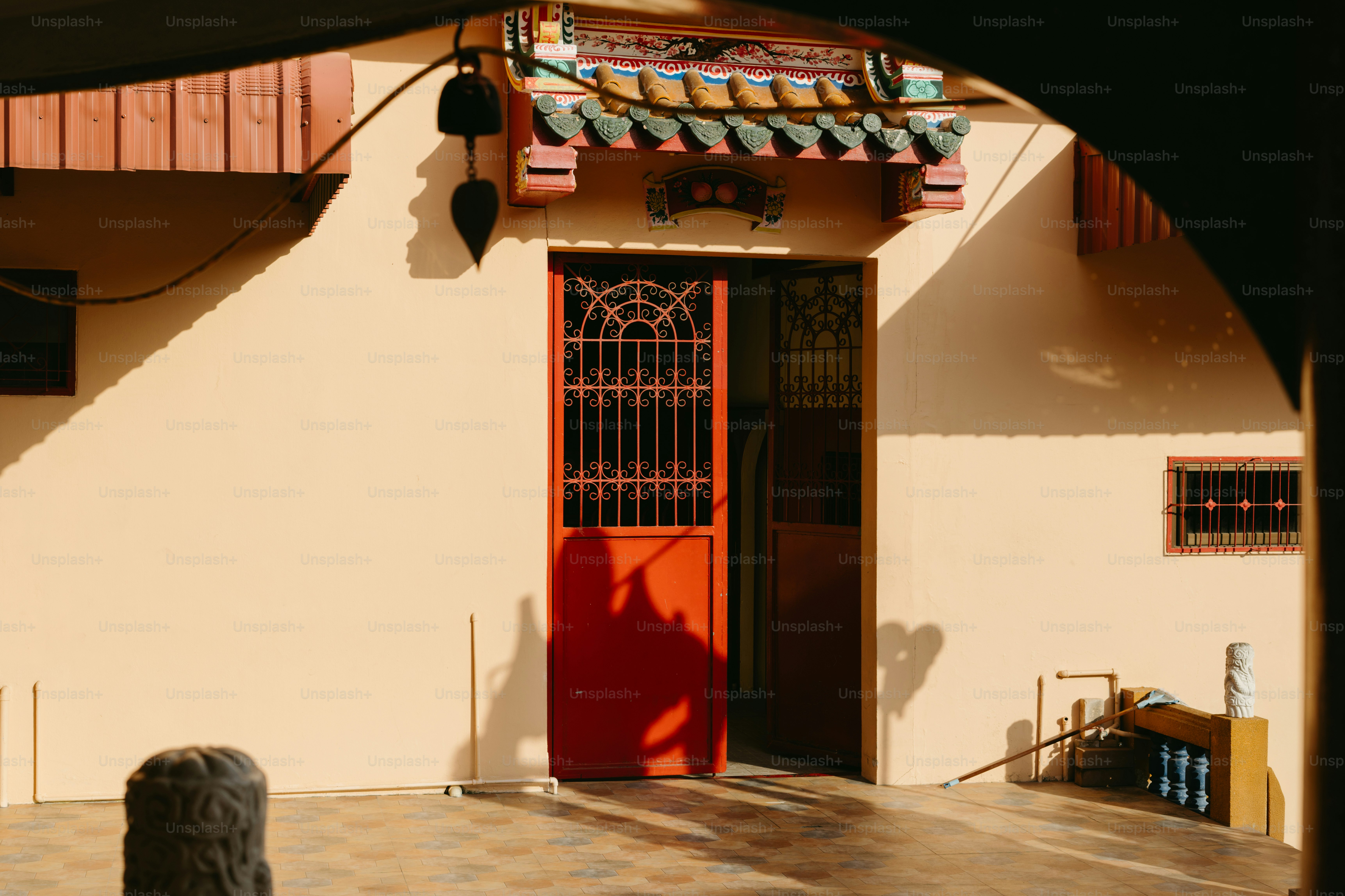 A red door in front of a white building