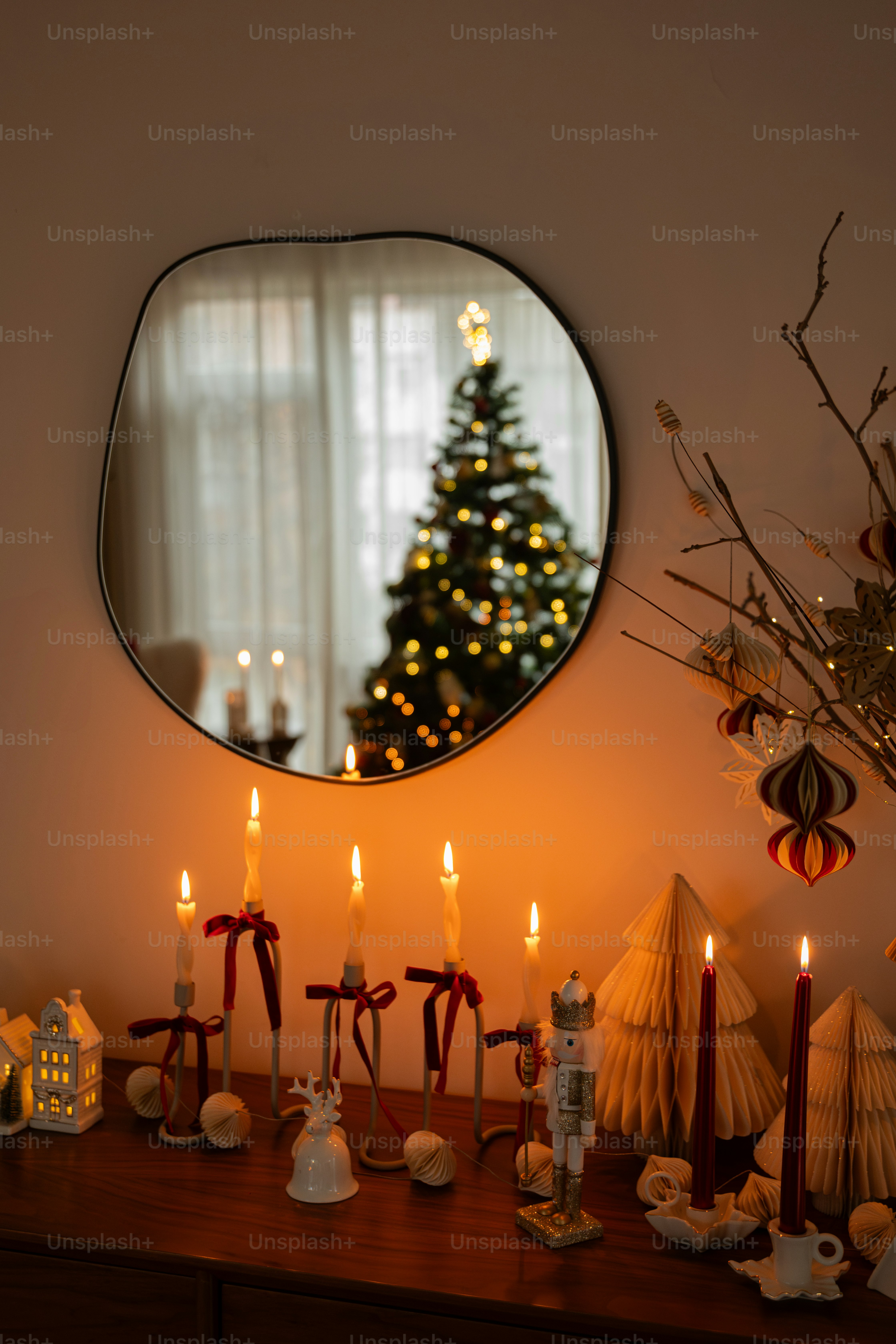 Un tavolo sormontato da uno specchio accanto a un albero di Natale