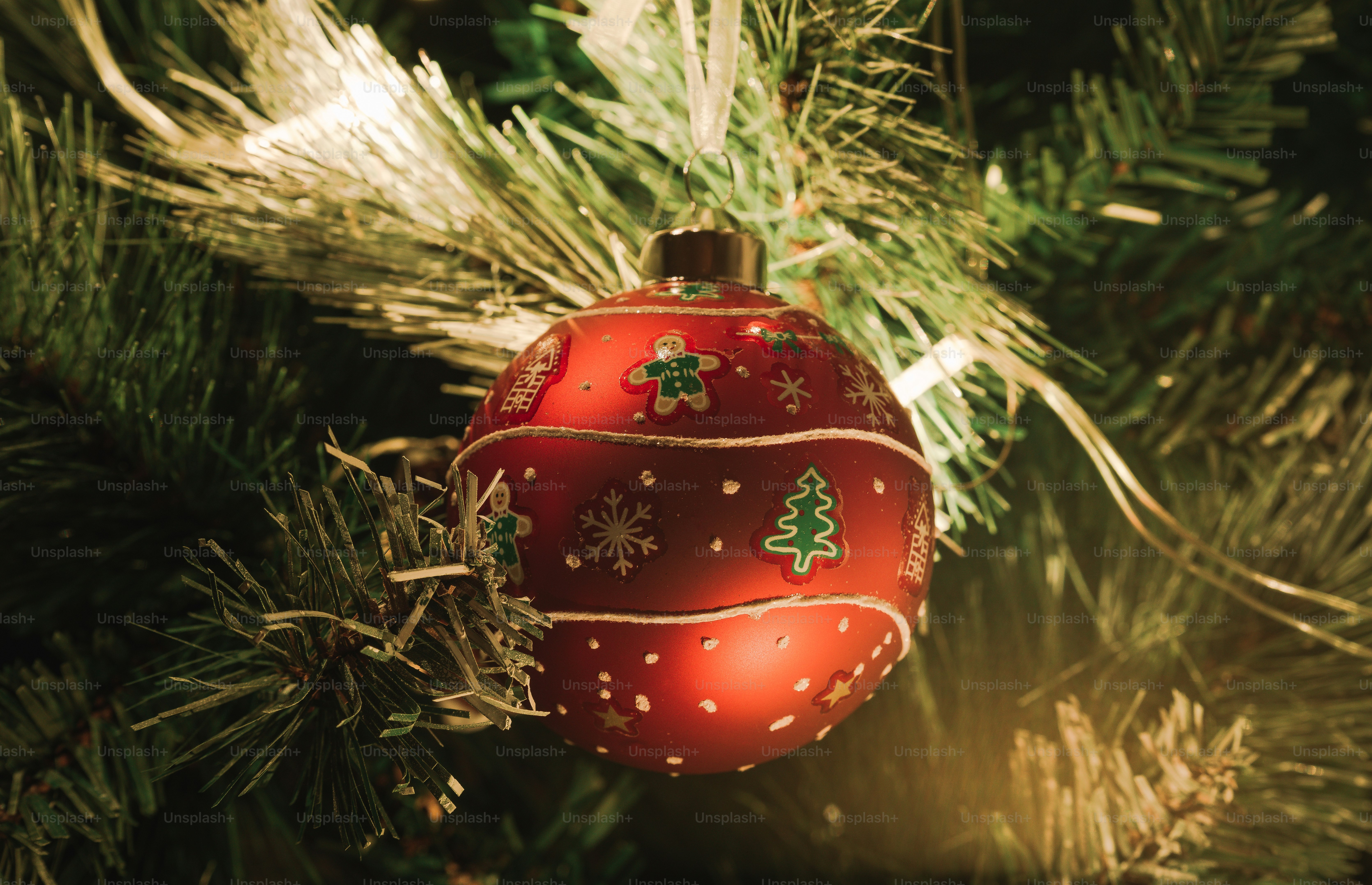 A red ornament hanging from a christmas tree