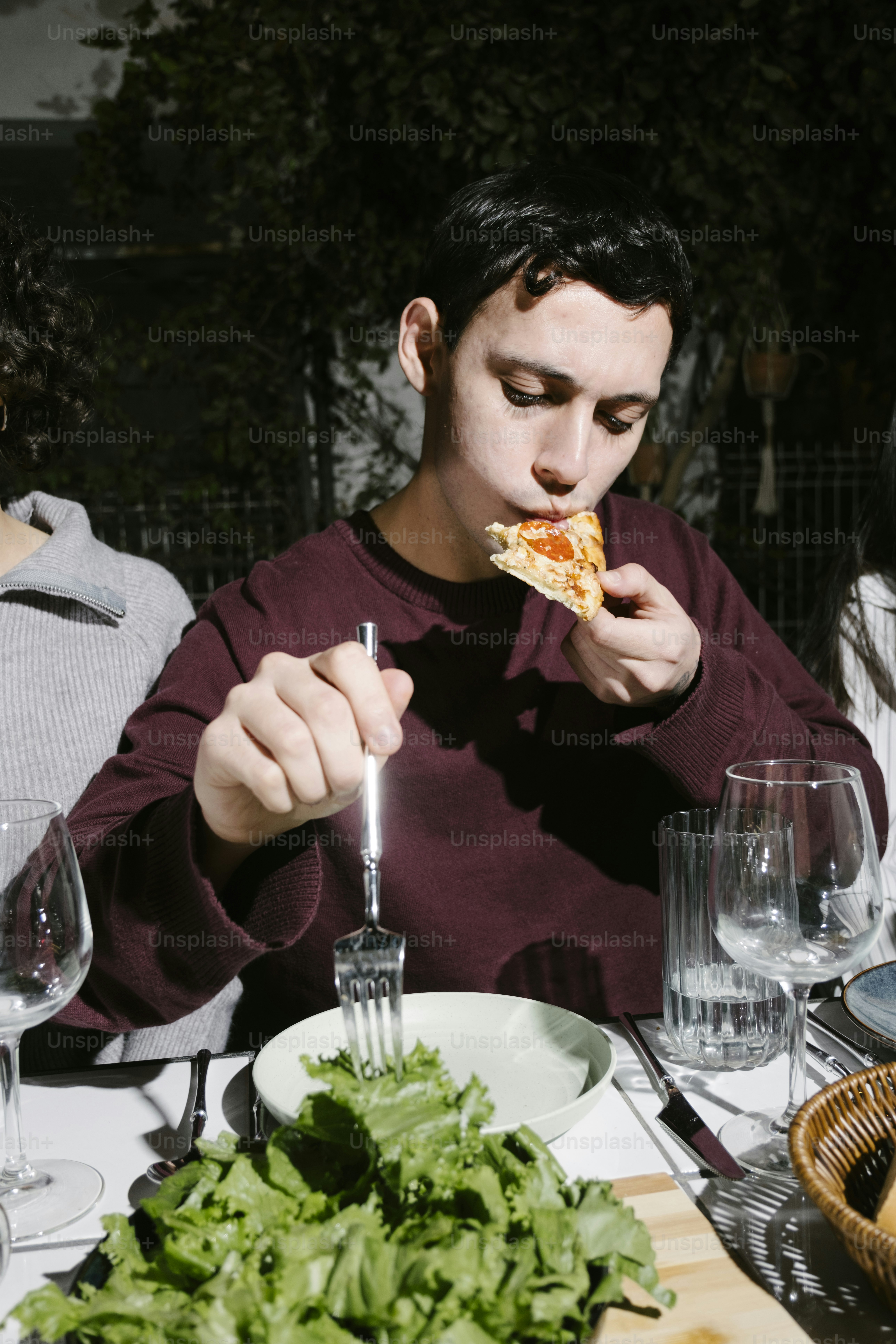 A man eating a slice of pizza at a table